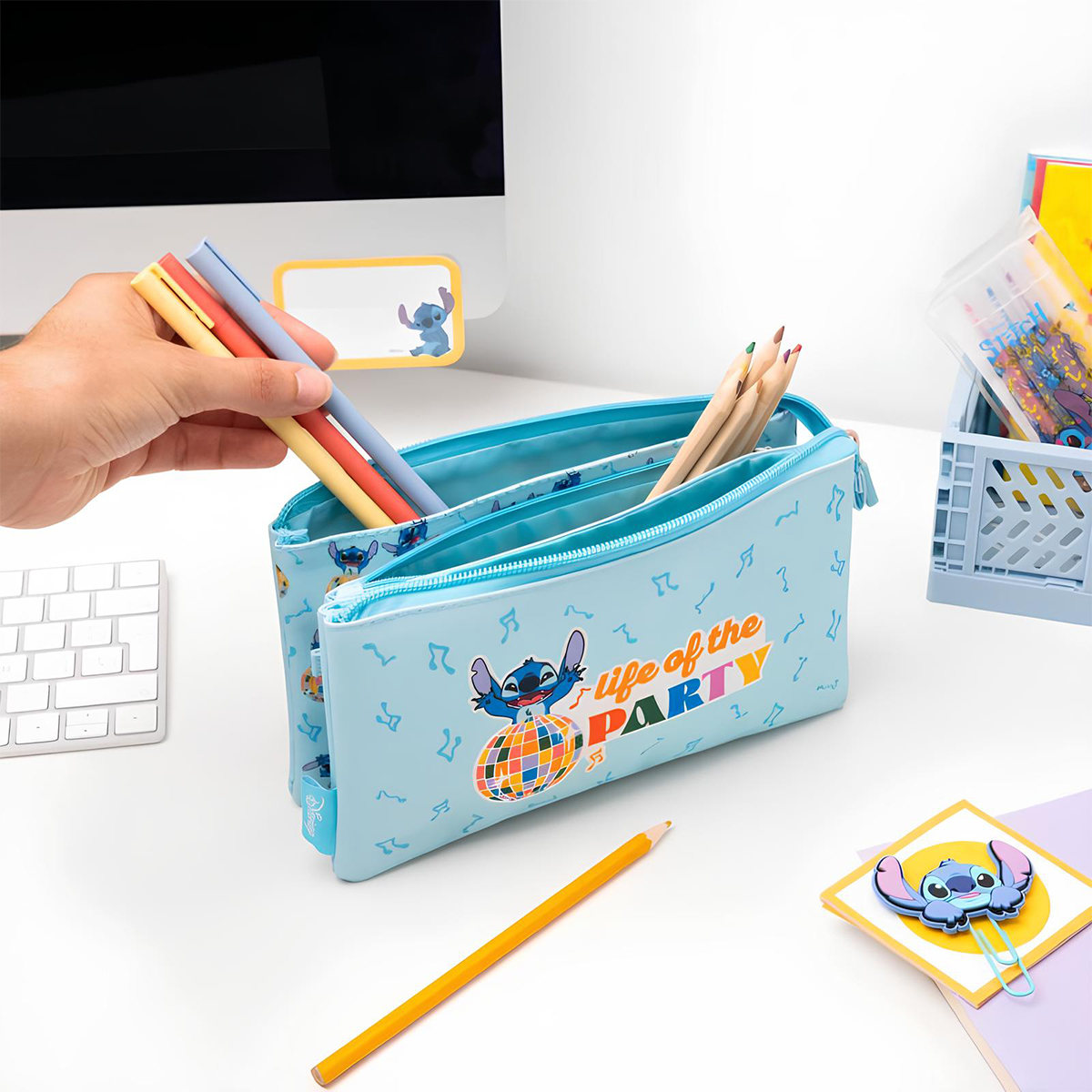 Hellblaue Federtasche mit Stitch-Motiv, Stifte und Buntstifte auf einem Schreibtisch.