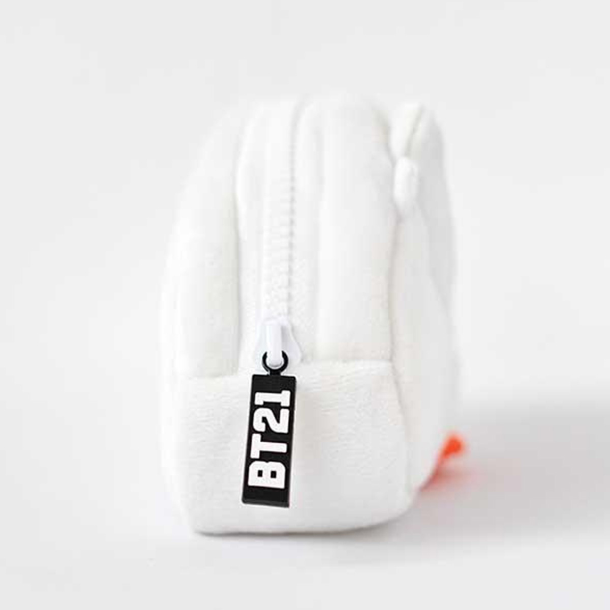 Ein weißer, flauschiger Beutel mit einem Reißverschluss und dem "BT21"-Logo.