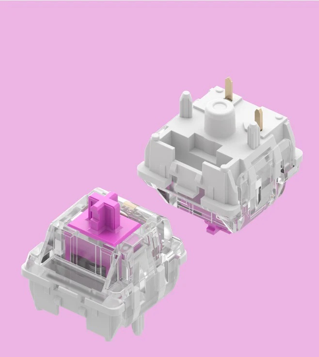 Due switch per tastiera meccanica, uno rosa, uno bianco, su sfondo rosa.