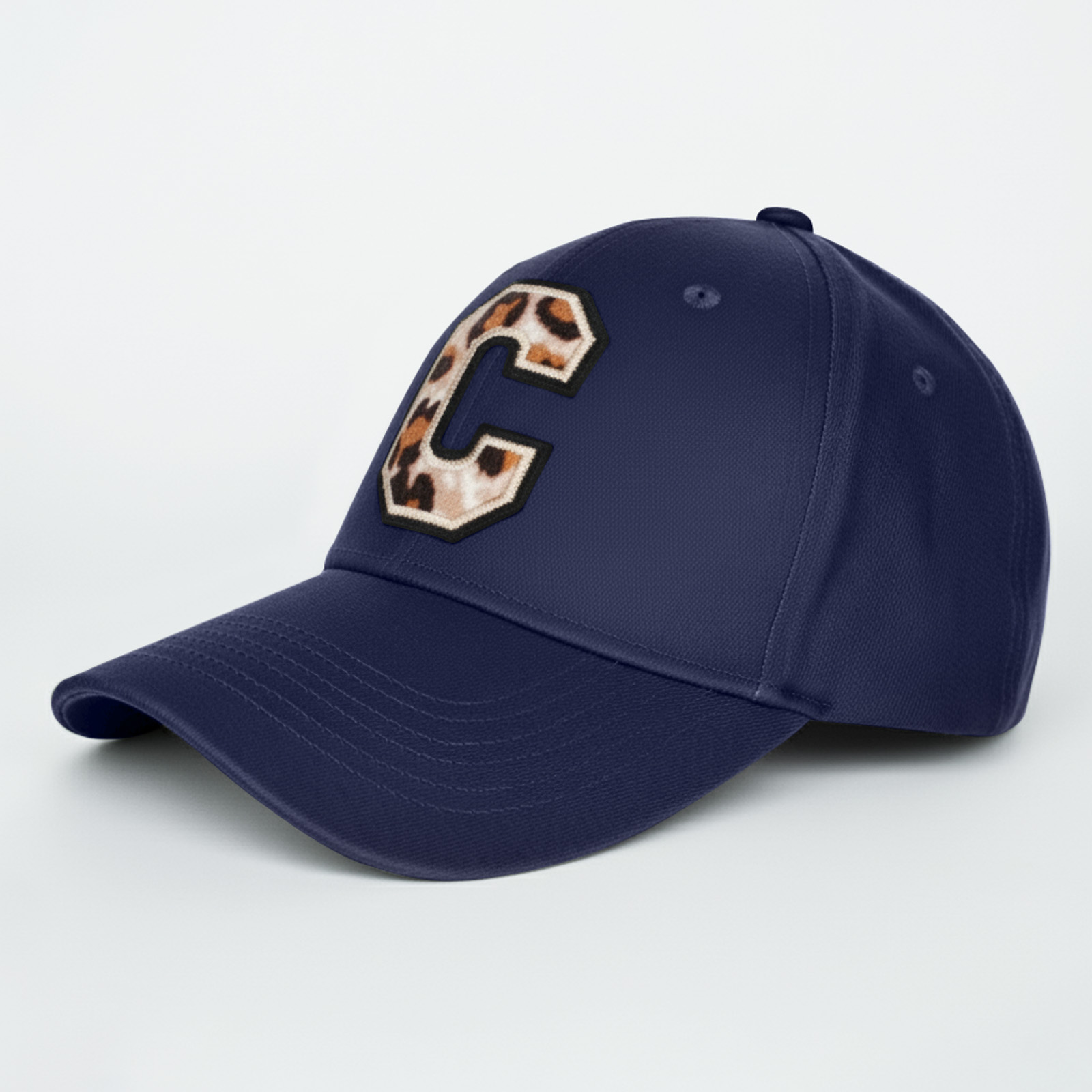 Dunkelblaue Kappe mit Leopardenmuster-Applikation 'C'.