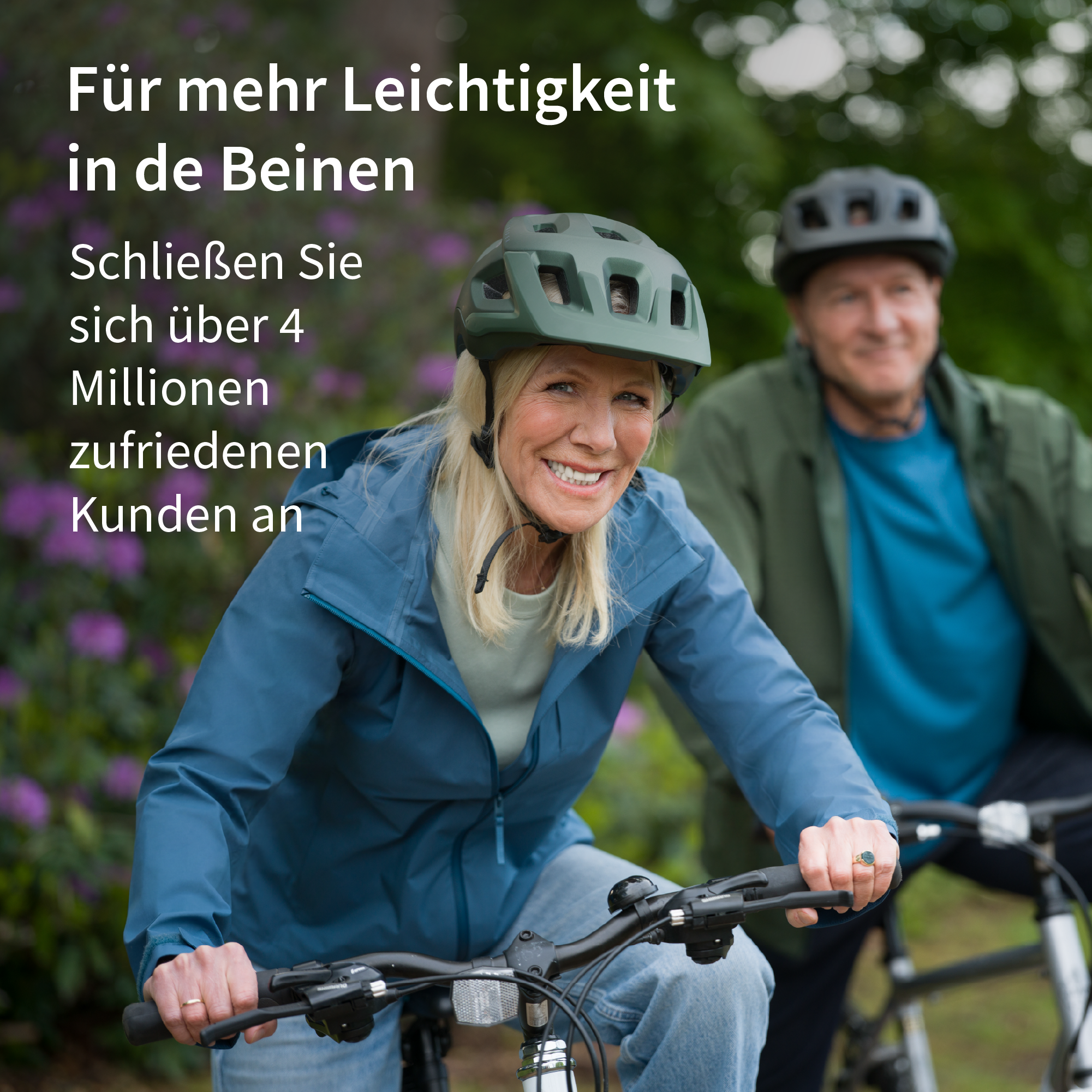 Ein lachendes Paar fährt Fahrrad im Freien, sie tragen Helme.