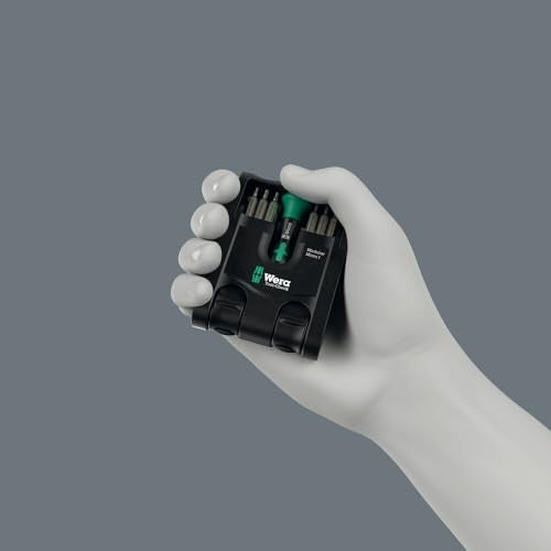 Eine Hand hält ein schwarzes Werkzeugset mit Schraubendrehern. Das Set hat einen grünen Griff.