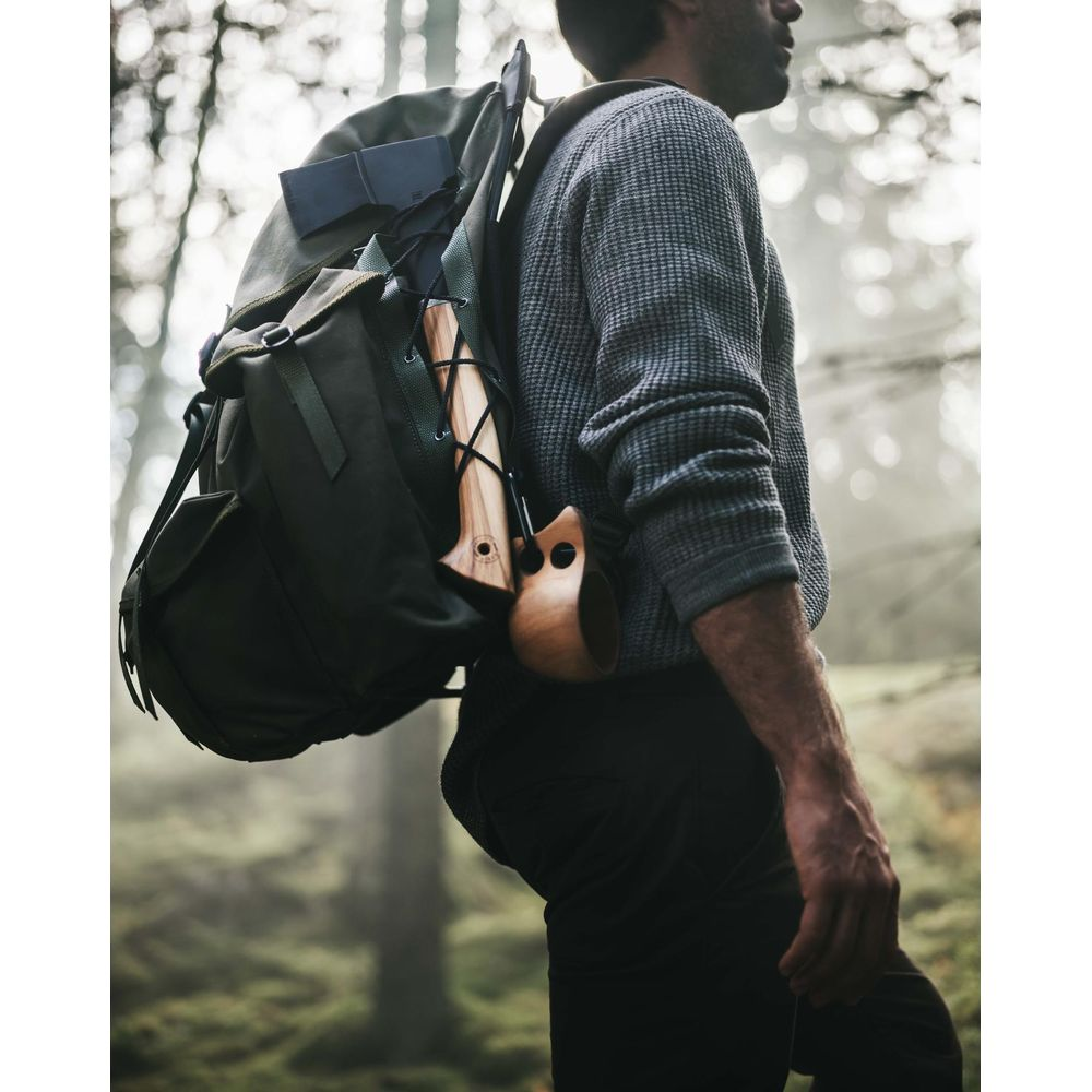 Ein Mann mit Rucksack und Axt im Wald.