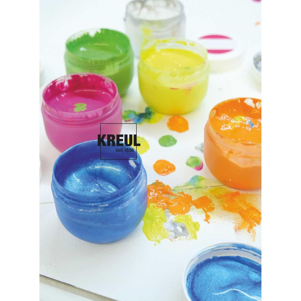Mehrere Döschen mit bunten Farben, darunter blau, pink, grün, gelb und orange.