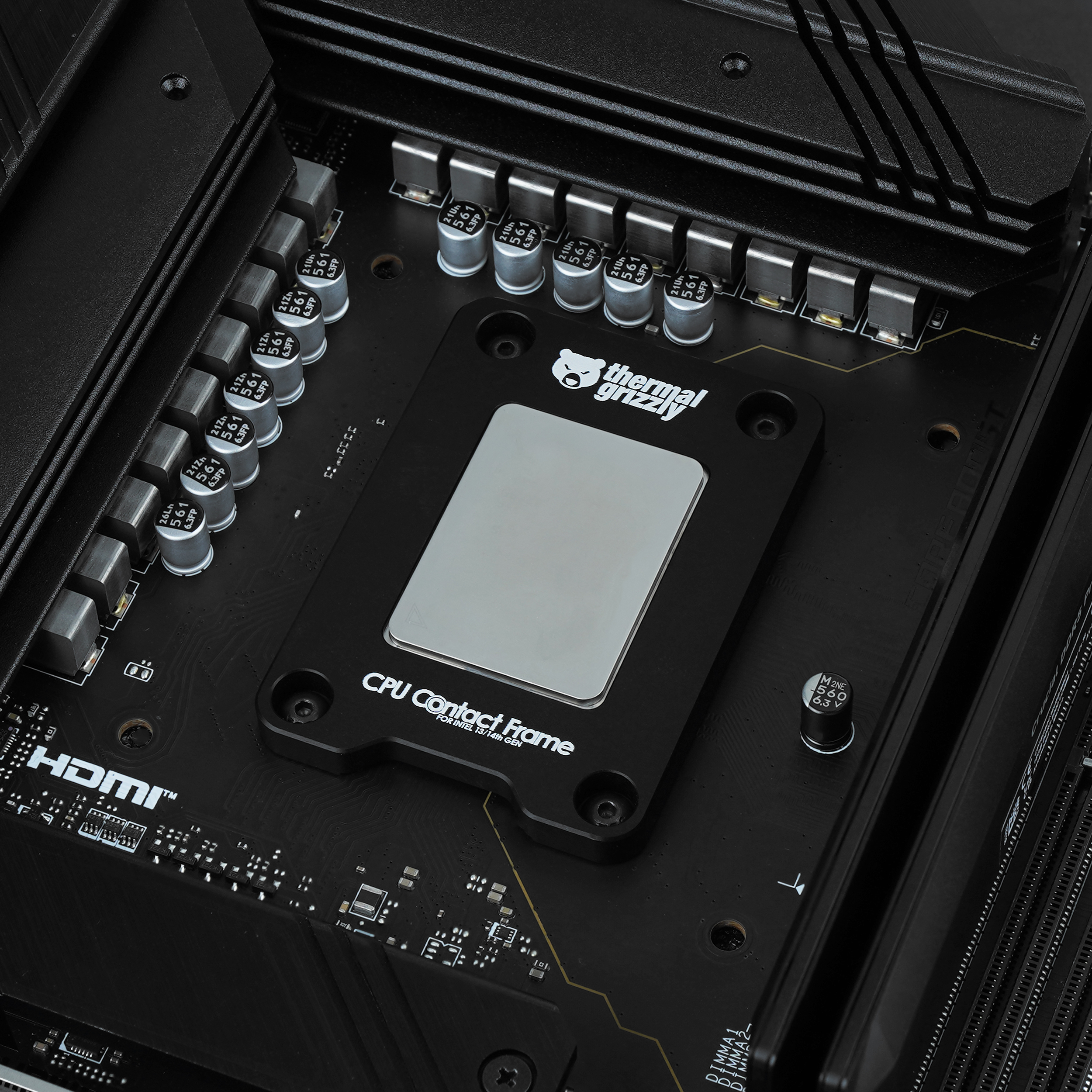 Detailaufnahme eines schwarzen CPU-Kontaktrahmens mit silberner Oberfläche auf einer Hauptplatine.