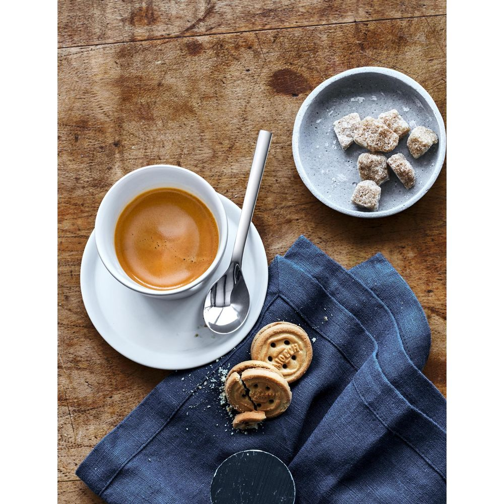 Eine Tasse Espresso, Zuckerwürfel und Kekse auf Holztisch.