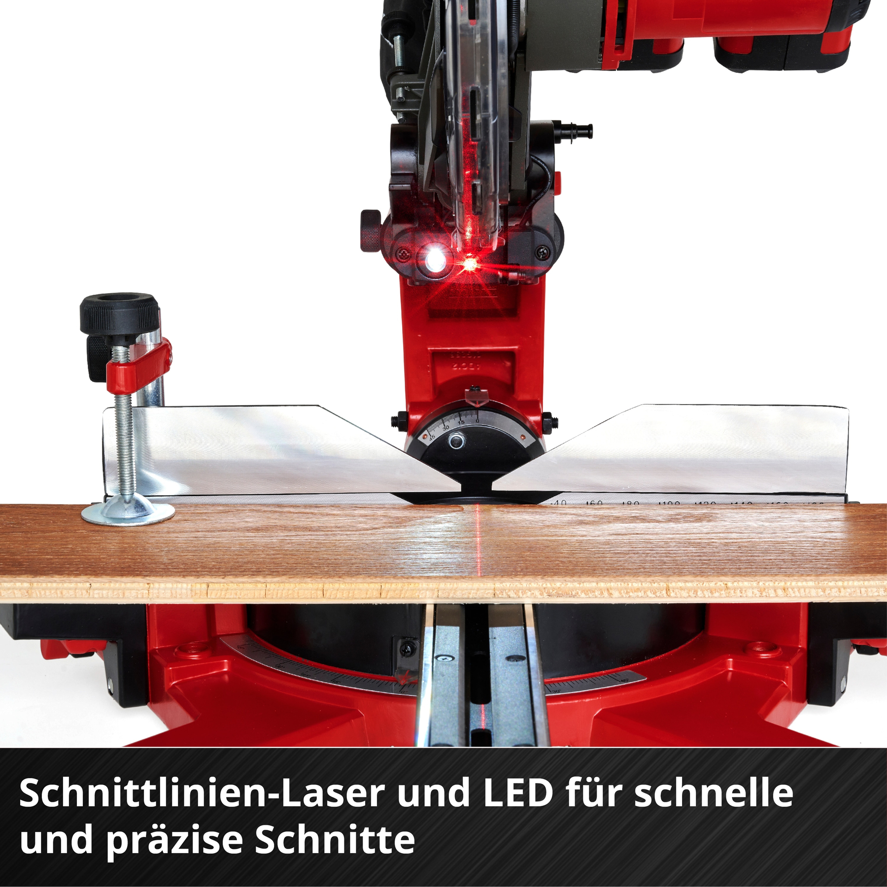 Rote Laserlinie und LED-Licht auf einem roten Sägeblatt, das auf Holz schneidet.