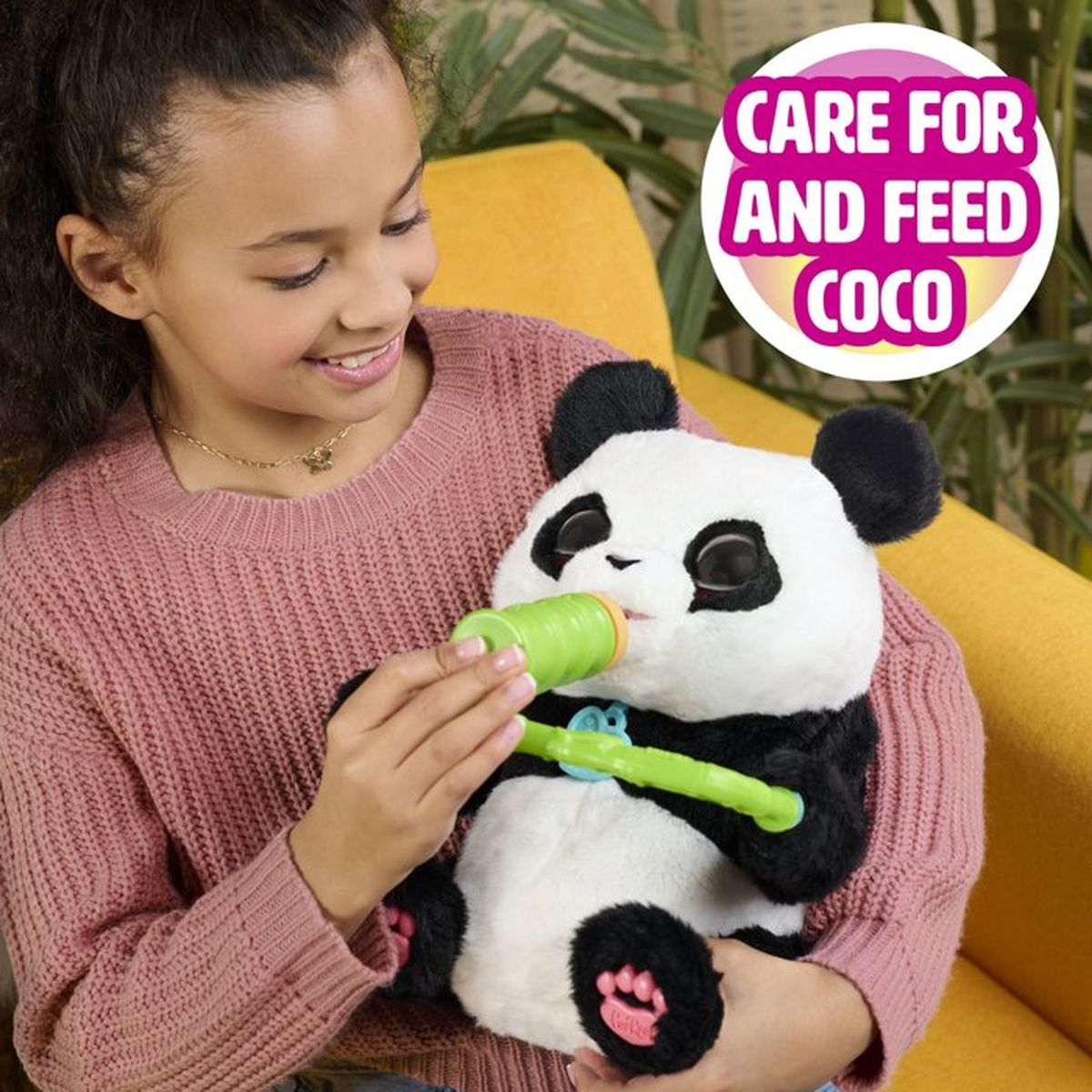 Una niña alimentando un peluche de panda con un biberón verde.