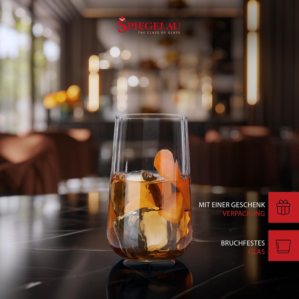 Ein Glas mit Eiswürfeln und Orangenschale, auf einem Marmortisch.