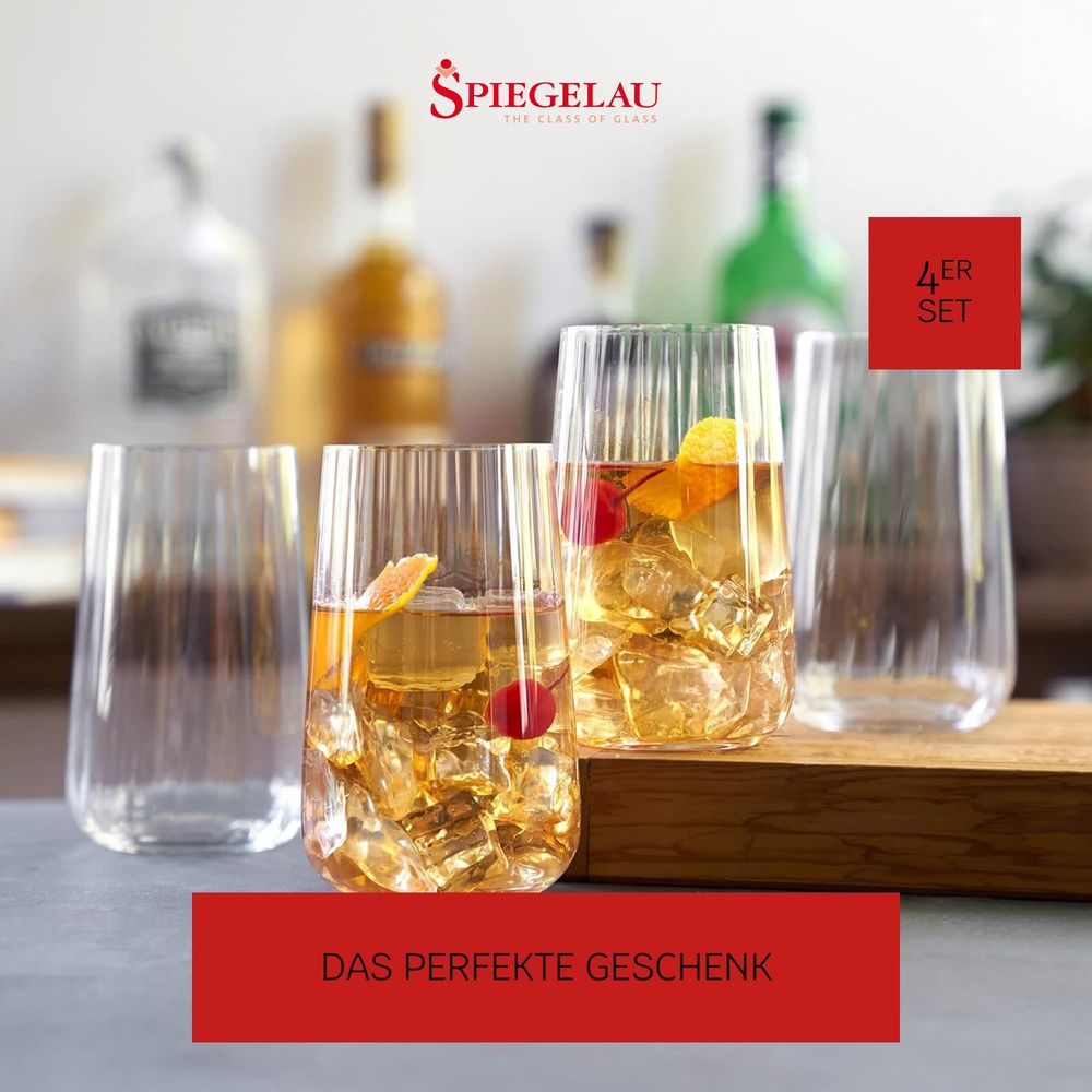Vier Gläser mit Eis und Fruchtgarnitur, im Hintergrund Flaschen.