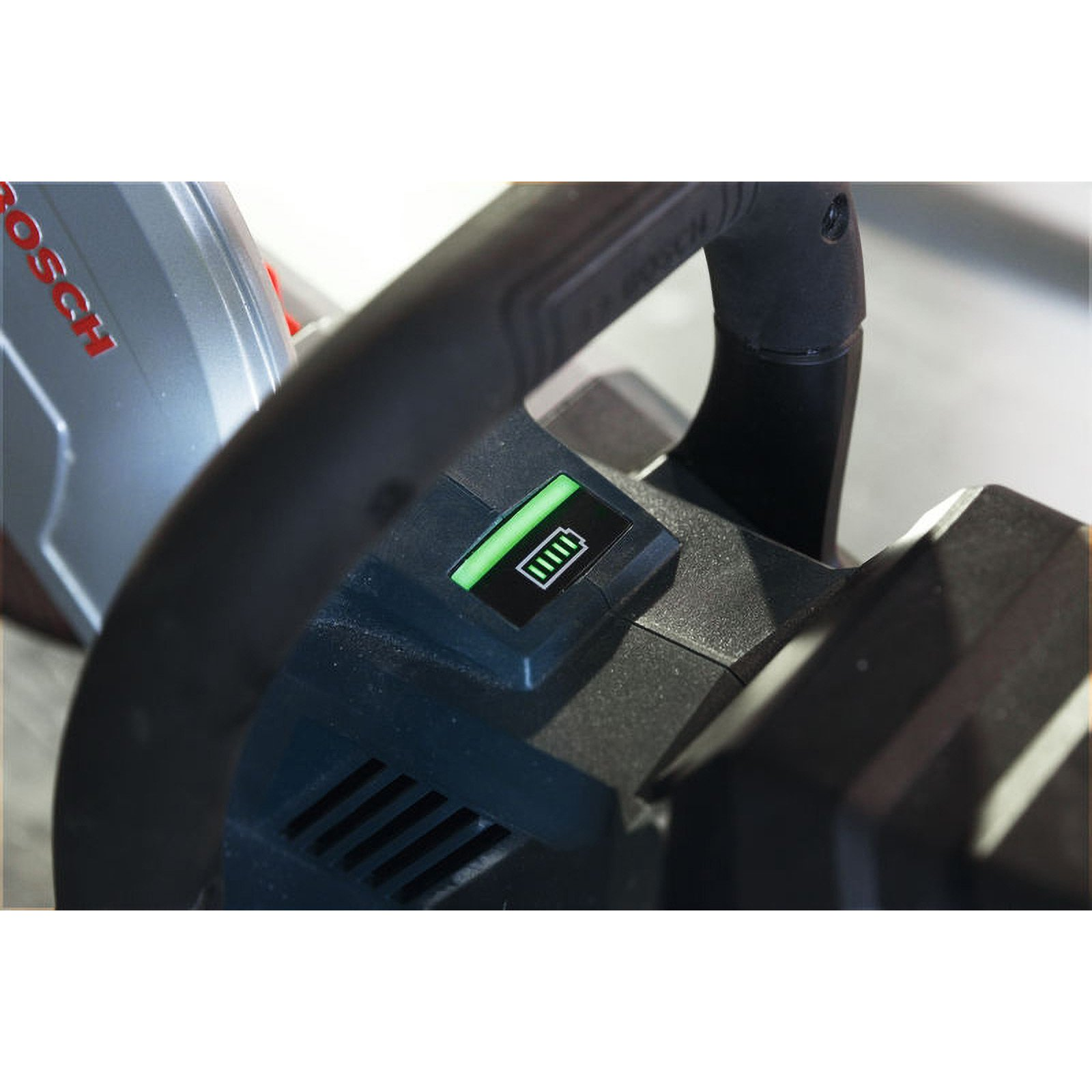 Nahaufnahme eines Elektrowerkzeugs mit einem grünen Akku-Ladeindikator.
