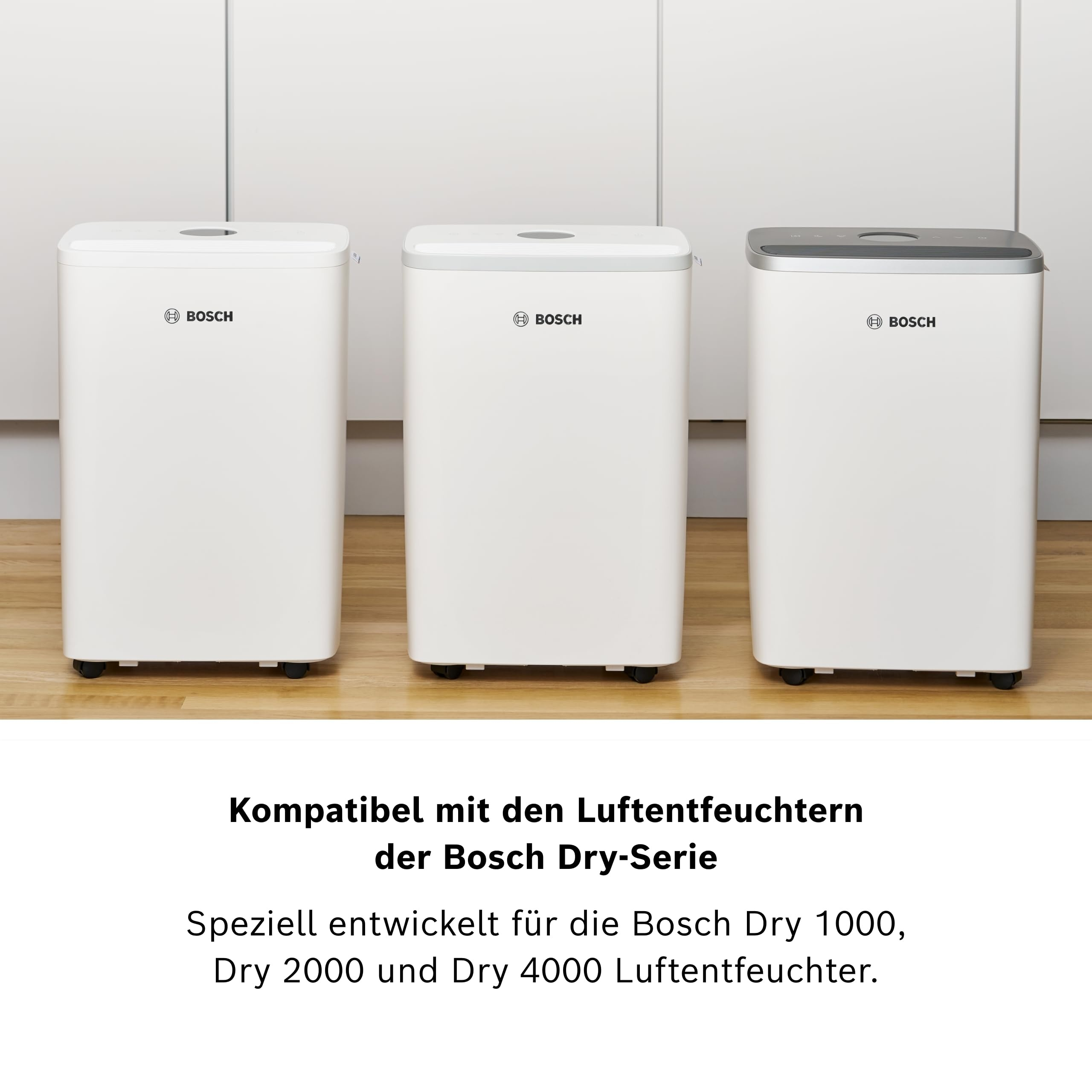 Drei weiße Bosch Luftentfeuchter mit Rollen auf Holzboden.