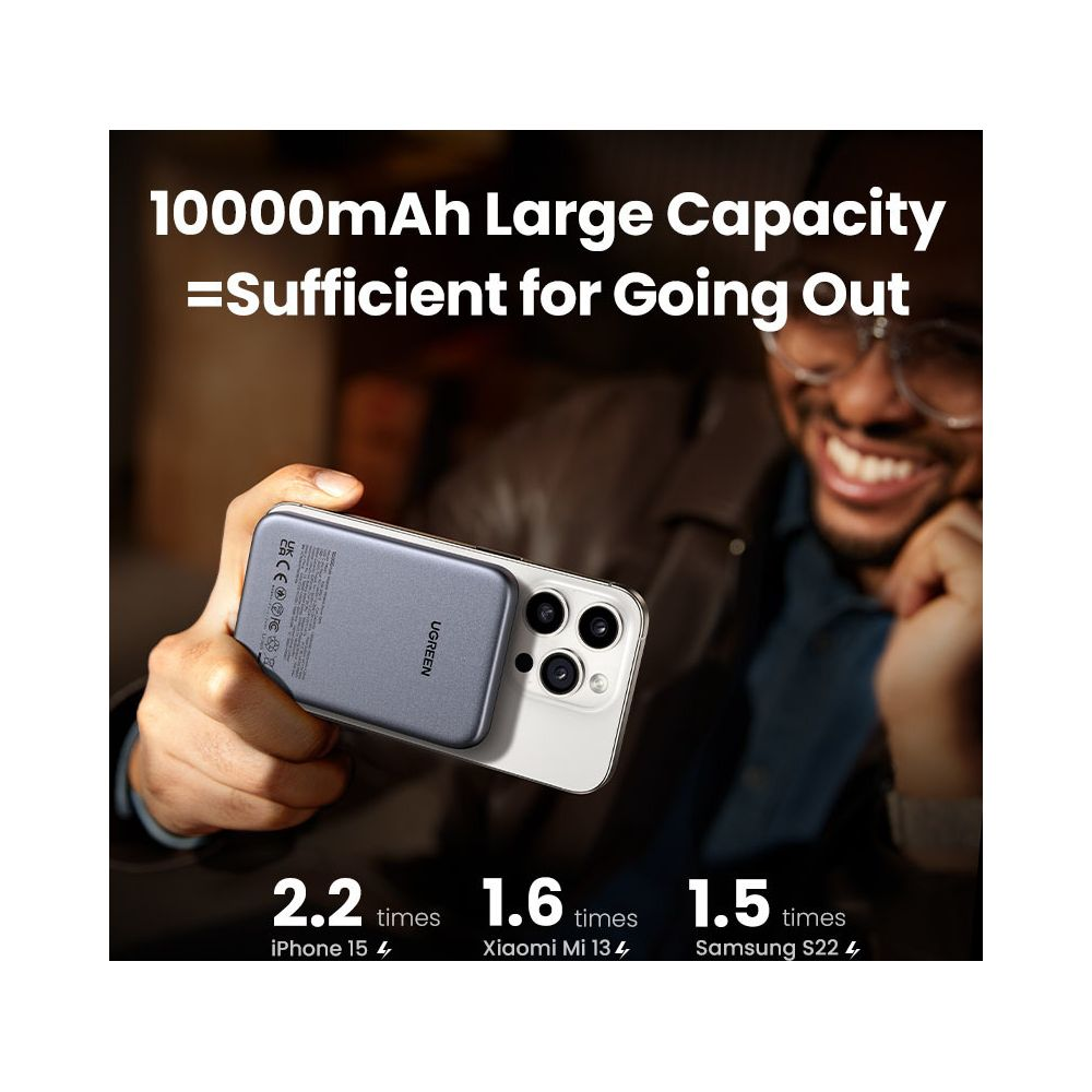 Gray power bank attached to iPhone 15. Man smiling.