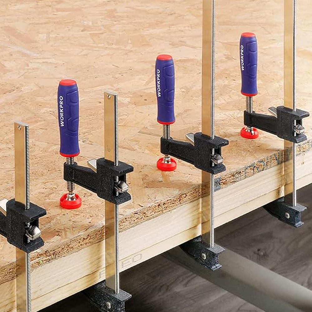 Dört mavi ve kırmızı WORKPRO kelepçesi tahta levhaları sabitliyor.