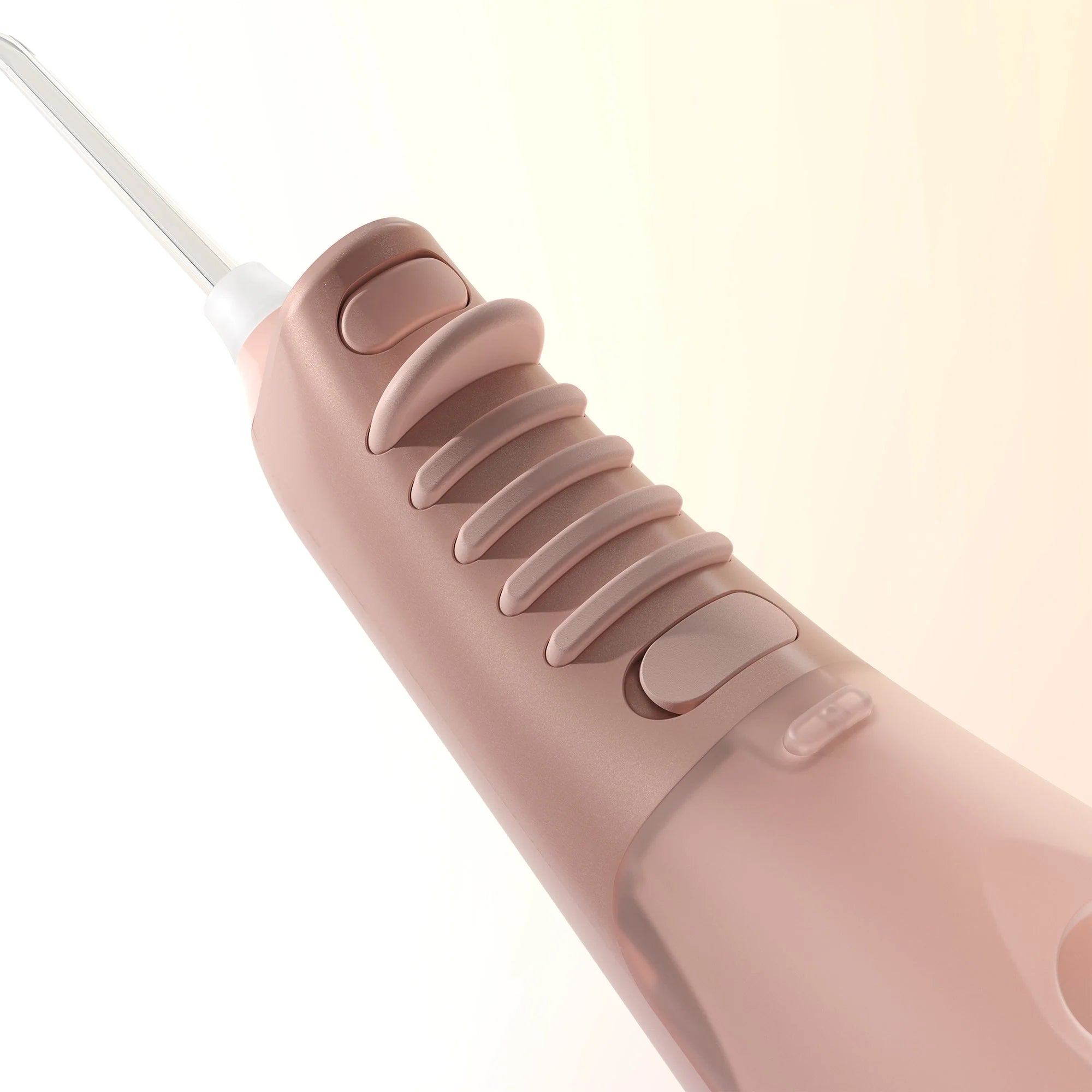 Primer plano de un cepillo de dientes eléctrico rosa con punta transparente y botones.