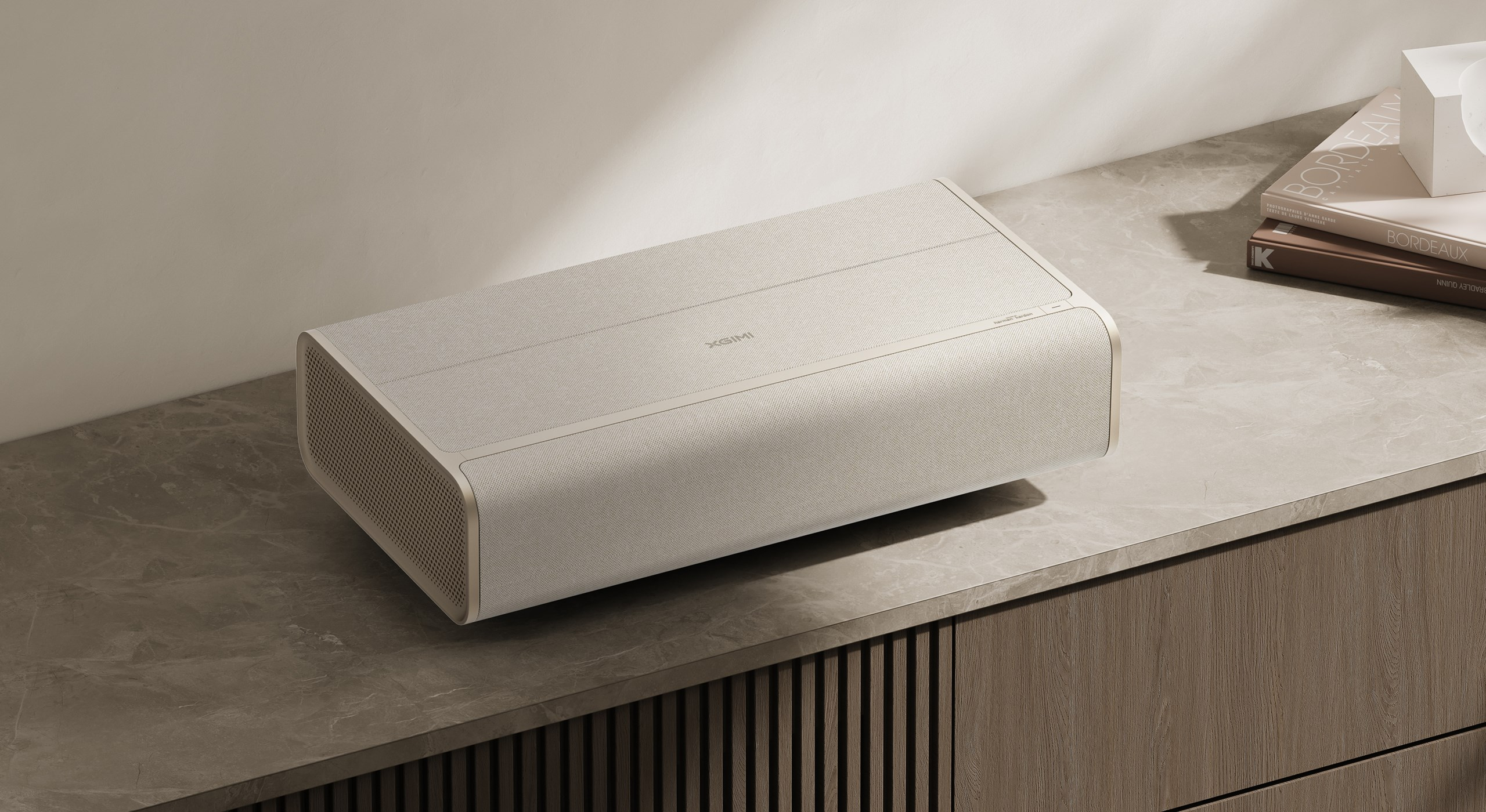Een beige projector staat naast boeken op een marmeren oppervlak.