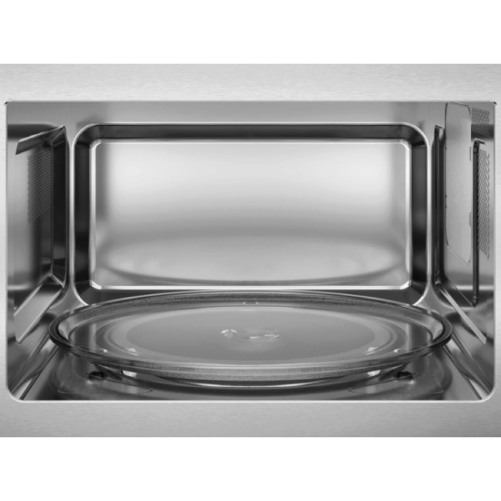 Interno di un forno a microonde con piatto girevole in vetro e pareti metalliche.