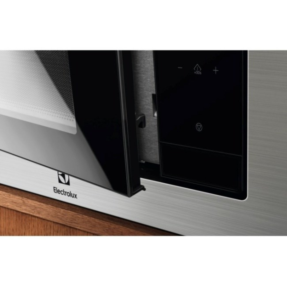 Primo piano della porta aperta di un microonde Electrolux con pannello di controllo nero.