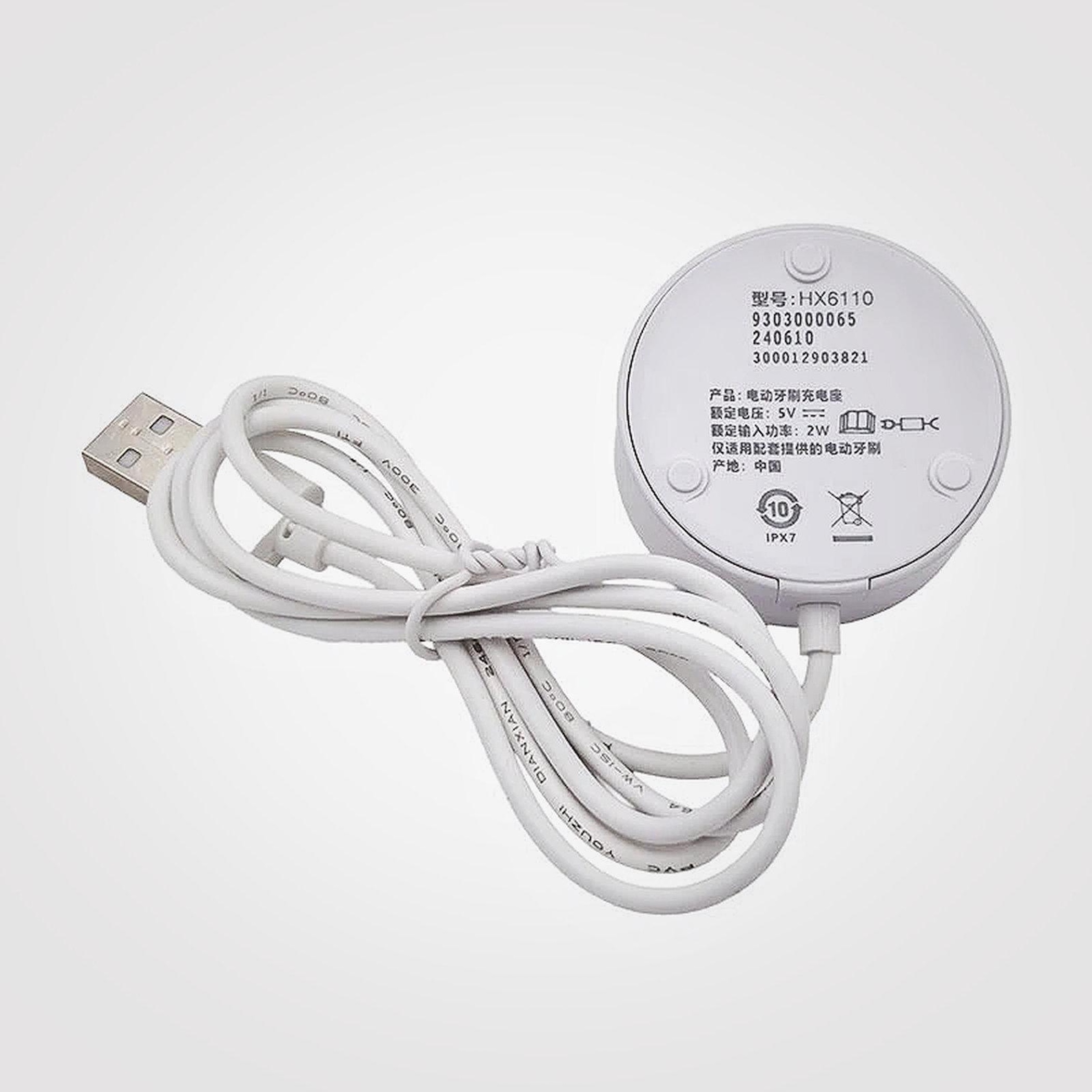 Ein weißes USB-Ladegerät mit Kabel für eine elektrische Zahnbürste.