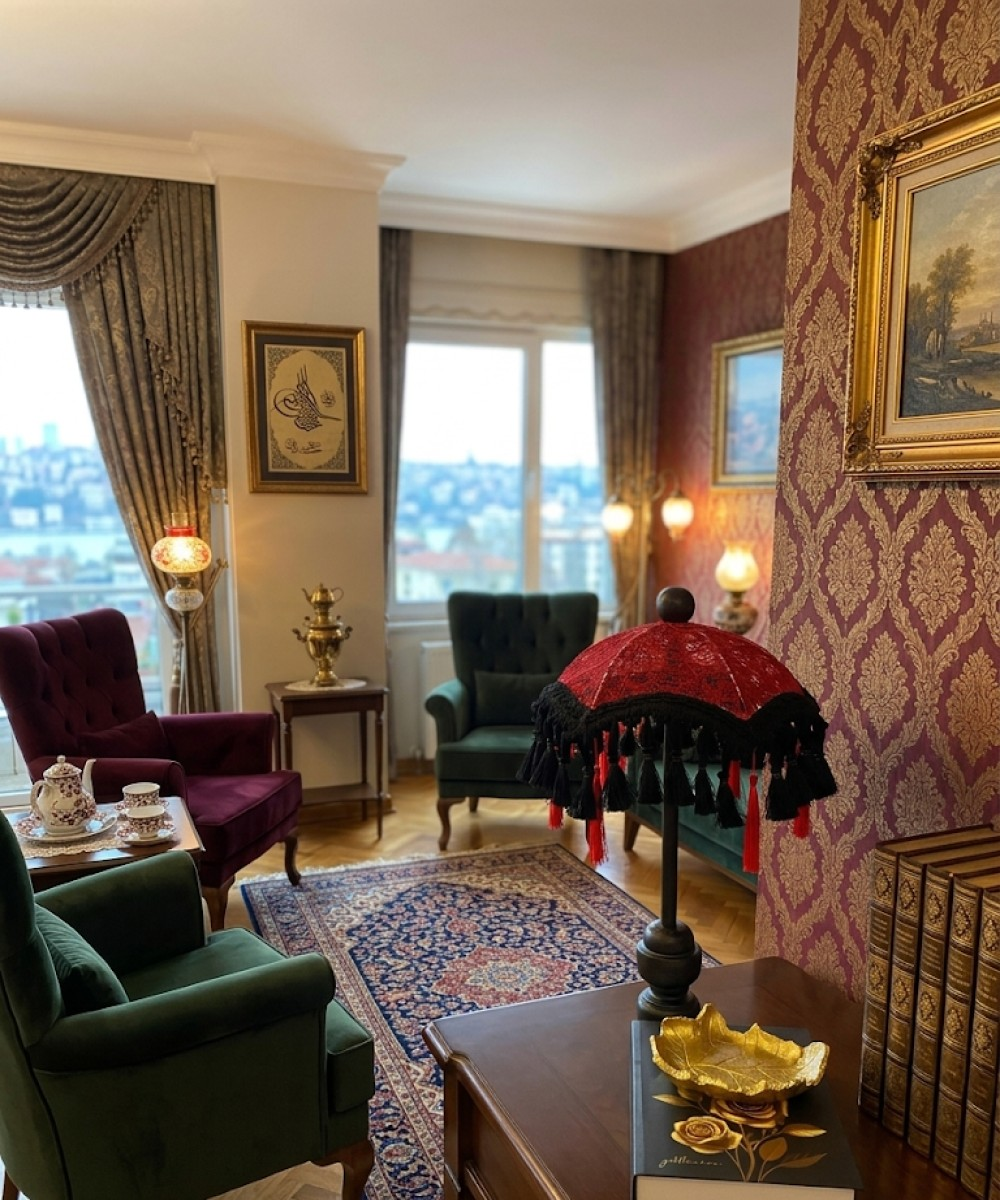İki koltuklu, halılı, masalı ve pencereli bir oturma odası.
