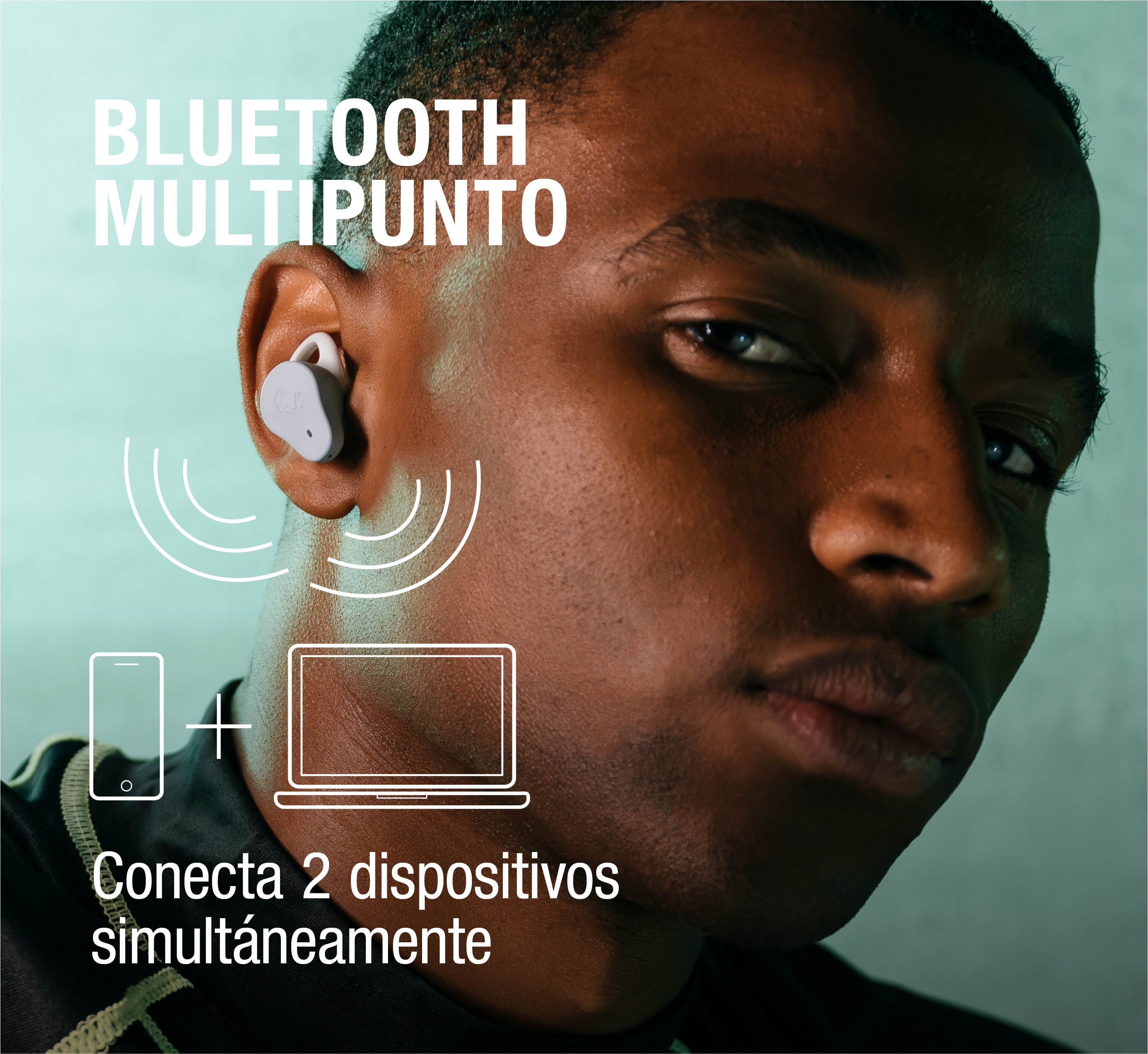 Hombre con auricular blanco conectando dos dispositivos a la vez.