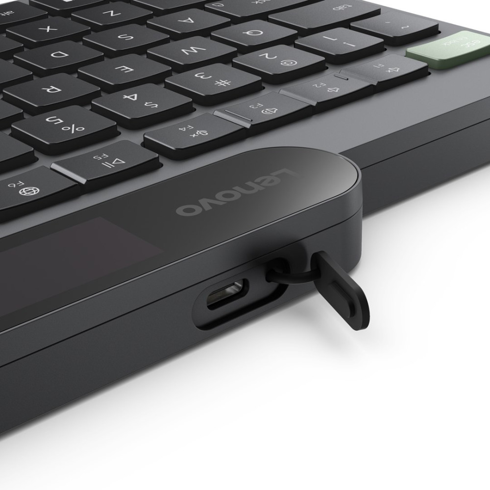 Zbliżenie na czarną klawiaturę laptopa Lenovo z portem USB-C i małym podłączonym urządzeniem.