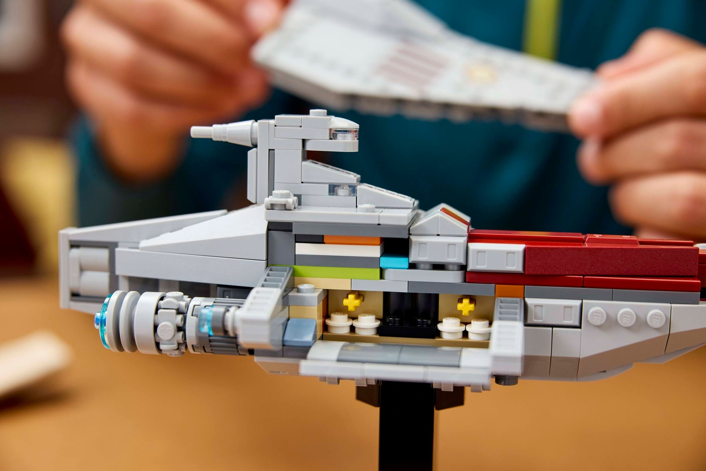 Ein graues Lego-Raumschiff mit roten Akzenten wird zusammengebaut.
