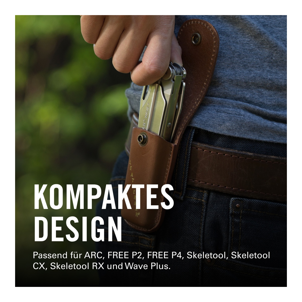 Eine Hand steckt ein silbernes Multitool in eine braune Ledertasche am Jeansbund.