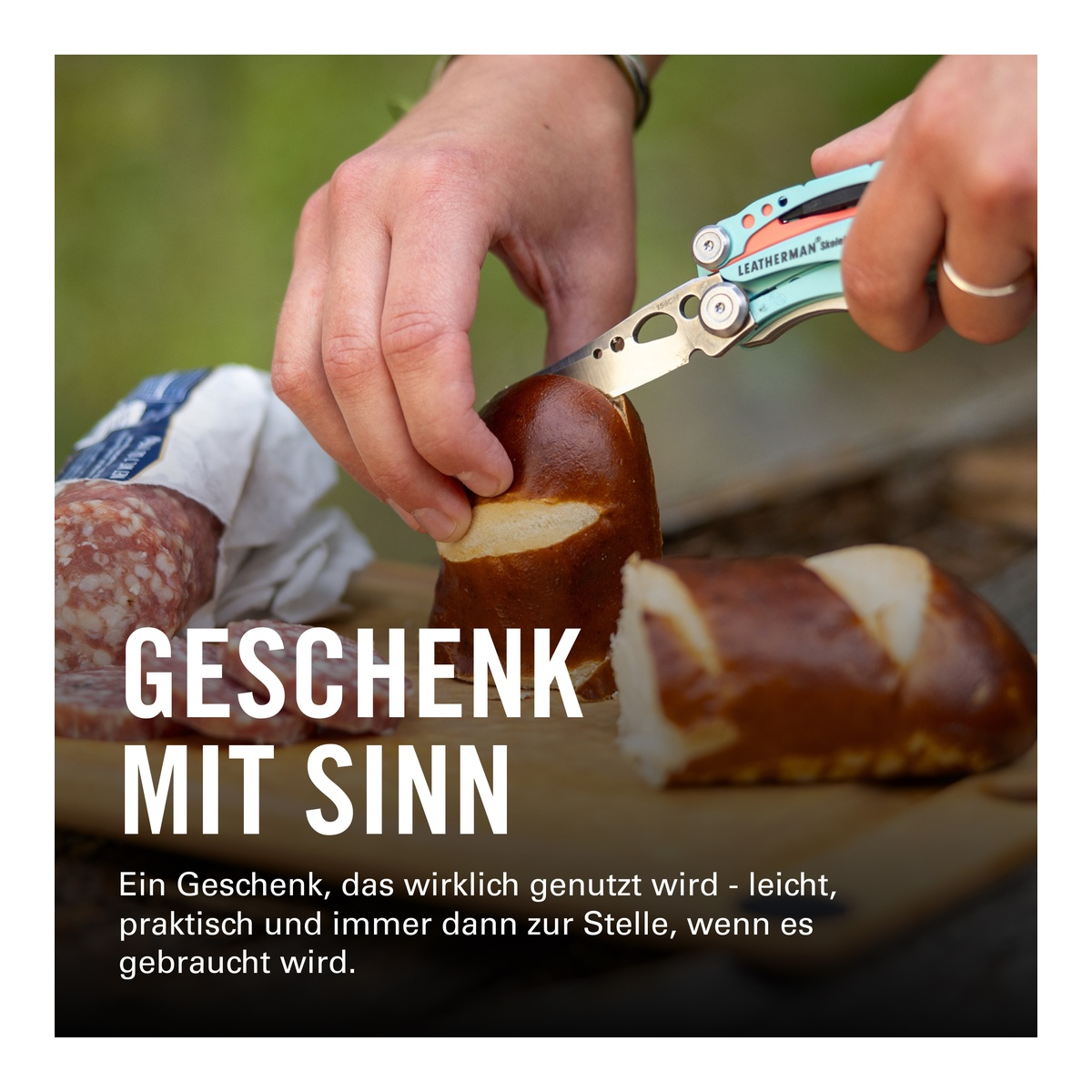 Hände schneiden Brezel mit Werkzeug. Wurst liegt daneben.