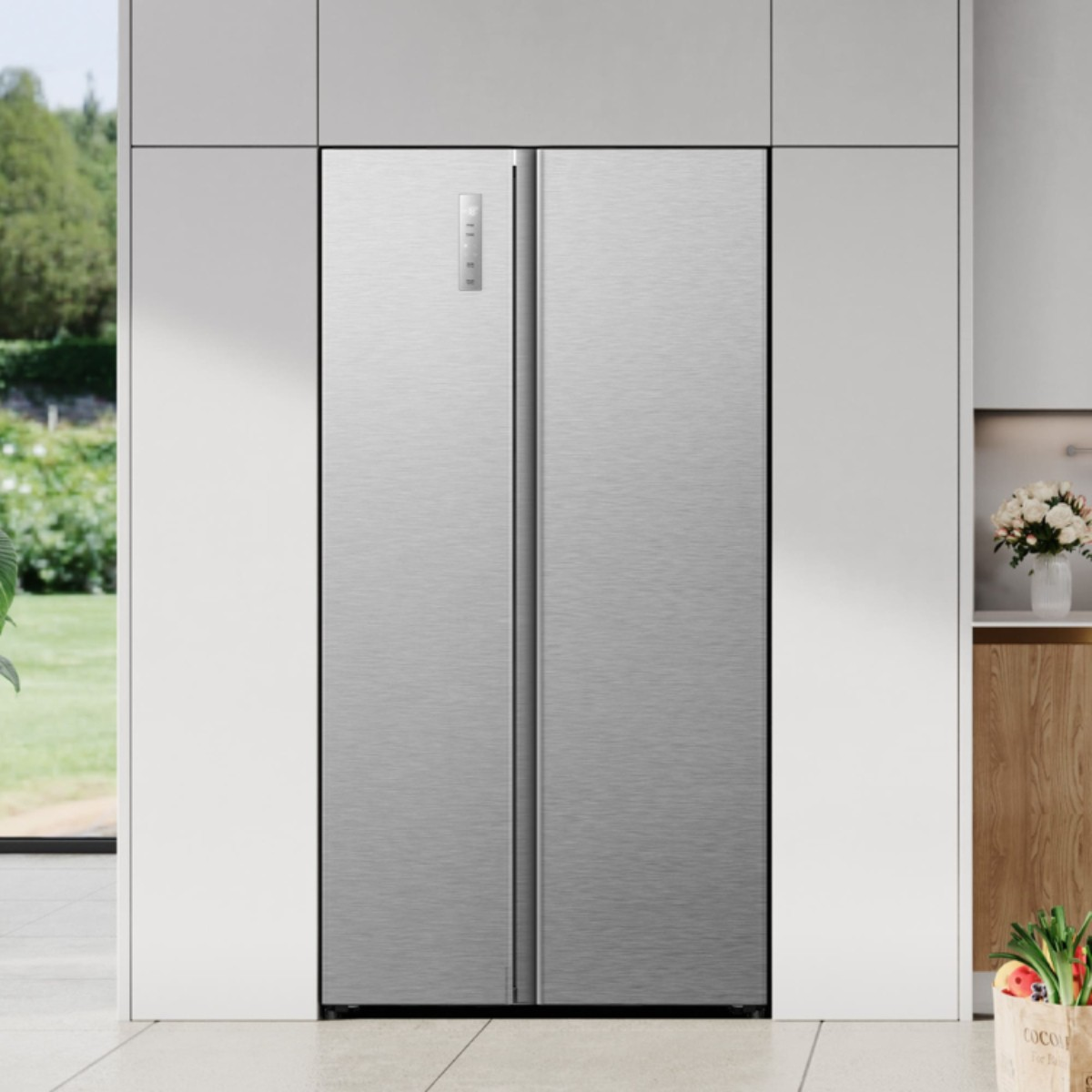 Ein moderner silberner Kühlschrank mit zwei Türen steht in einer Küche.