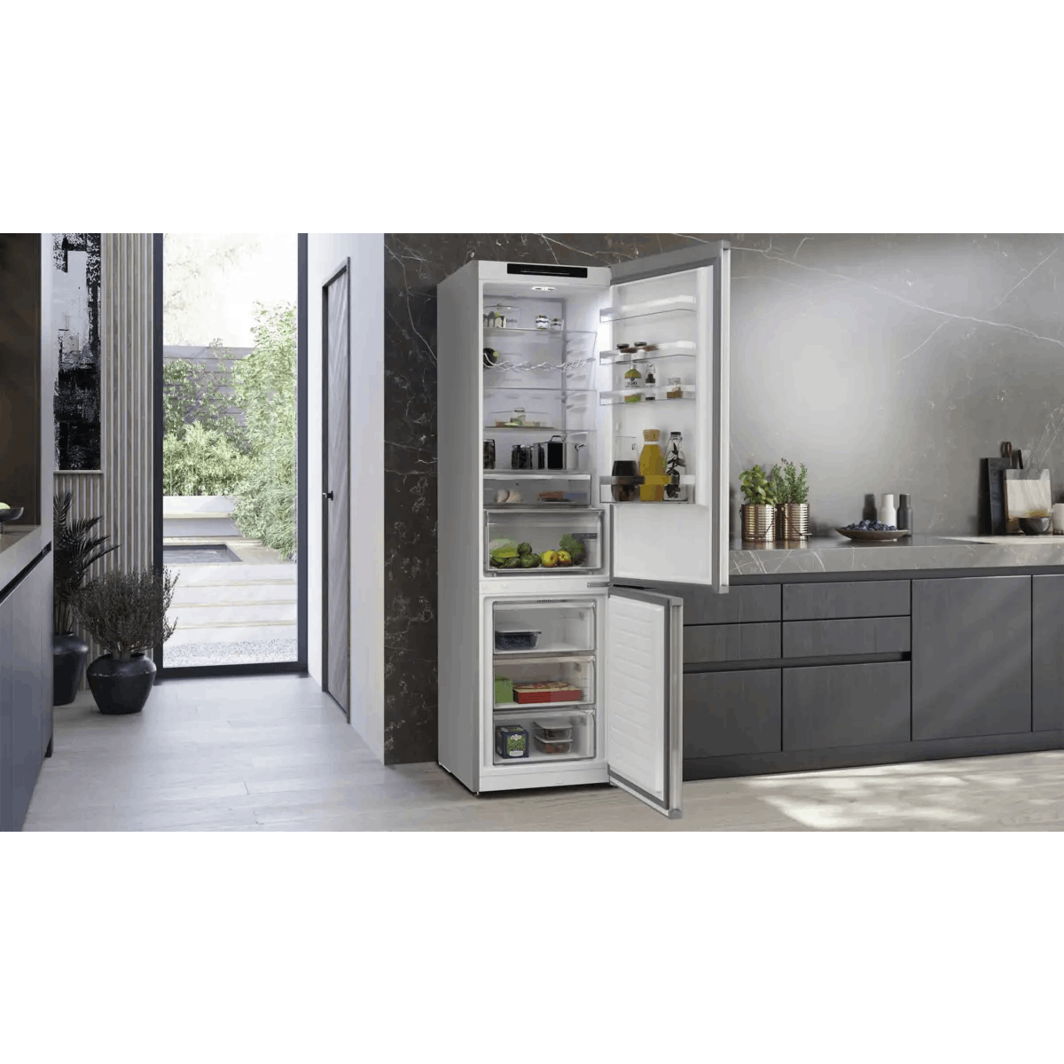 Un frigorifero aperto con cibo e cassetti in una cucina moderna.