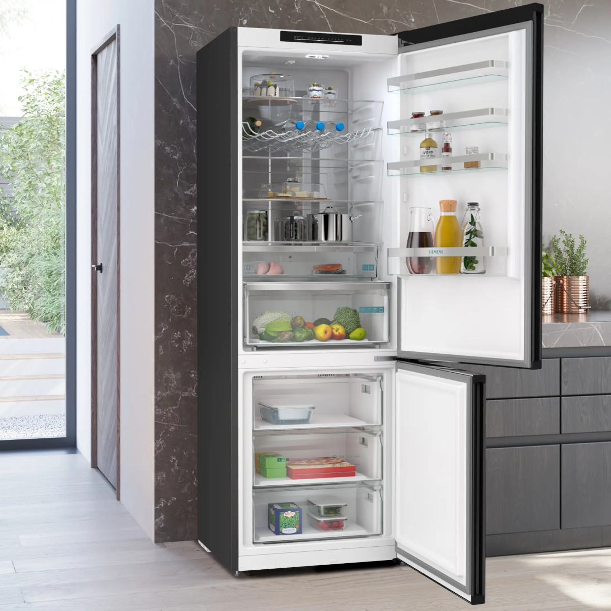 Ein offener Kühlschrank mit Lebensmitteln und Getränken, darunter Obst, Gemüse und Flaschen.