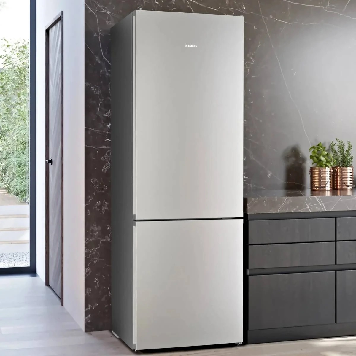 Un elegante frigorifero Siemens argentato si trova in una cucina moderna accanto ad armadi scuri.