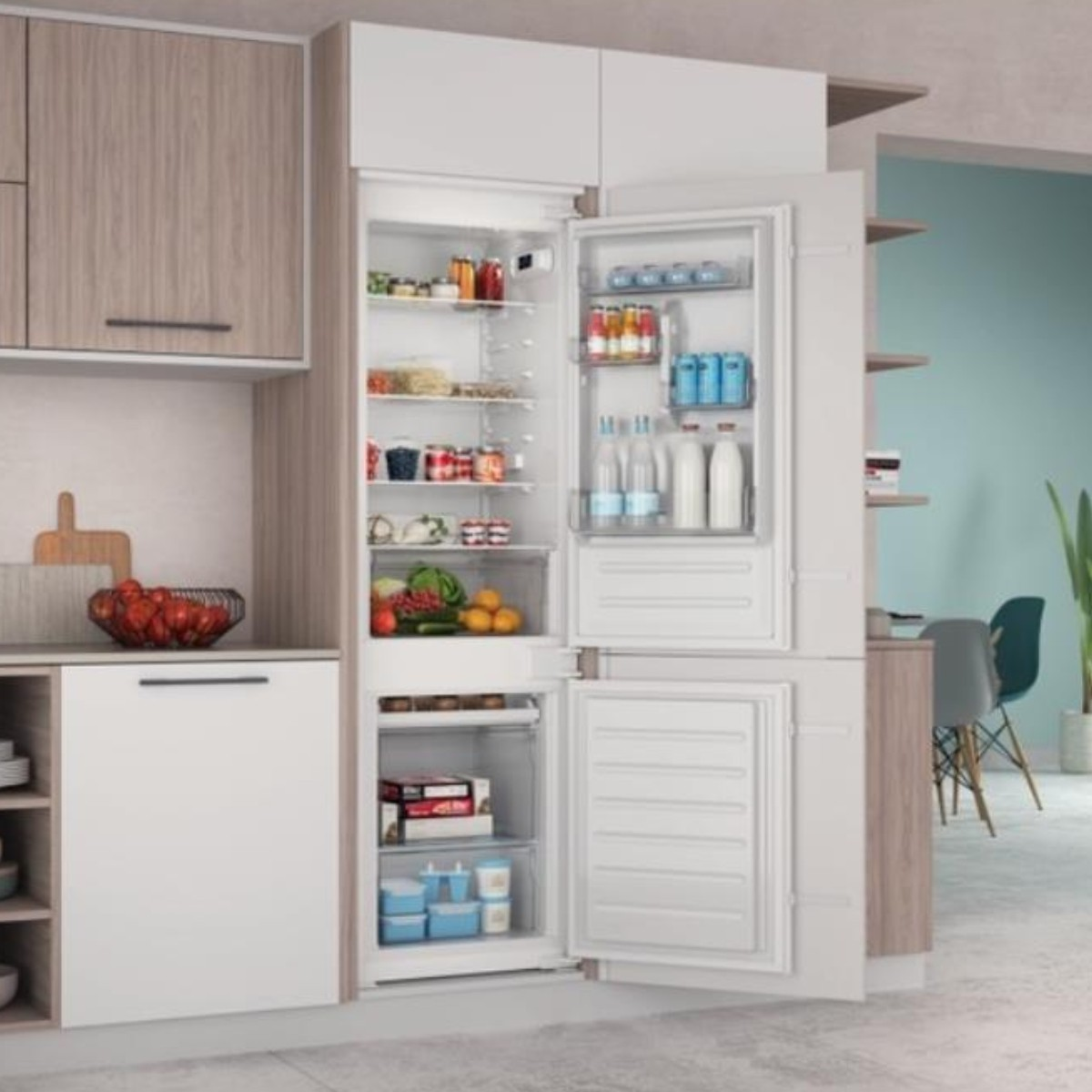 Een open koelkast gevuld met etenswaren in een moderne keuken.