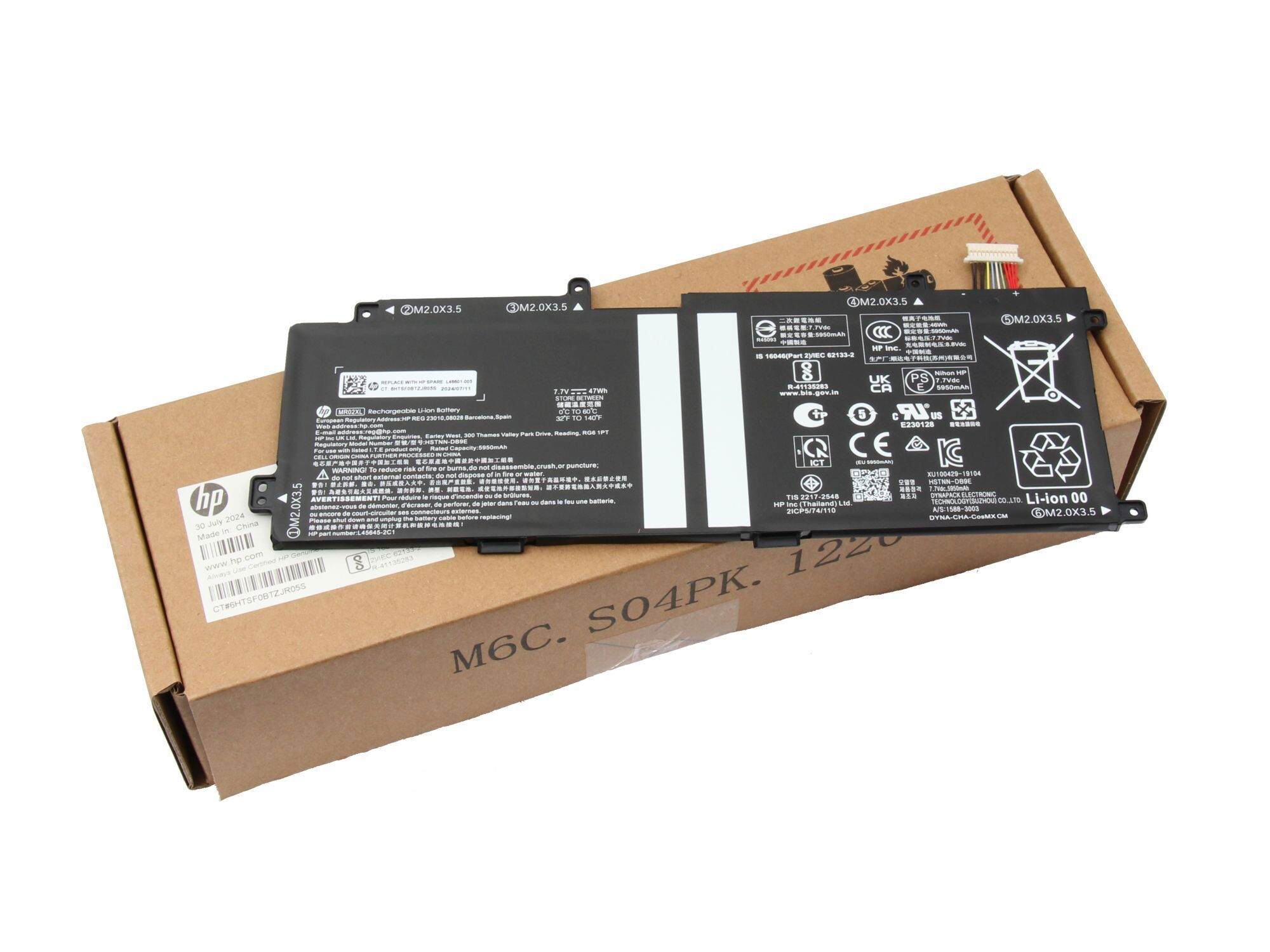 HP Laptop-Akku auf braunem Karton liegend, mit vielen technischen Details und Warnhinweisen.