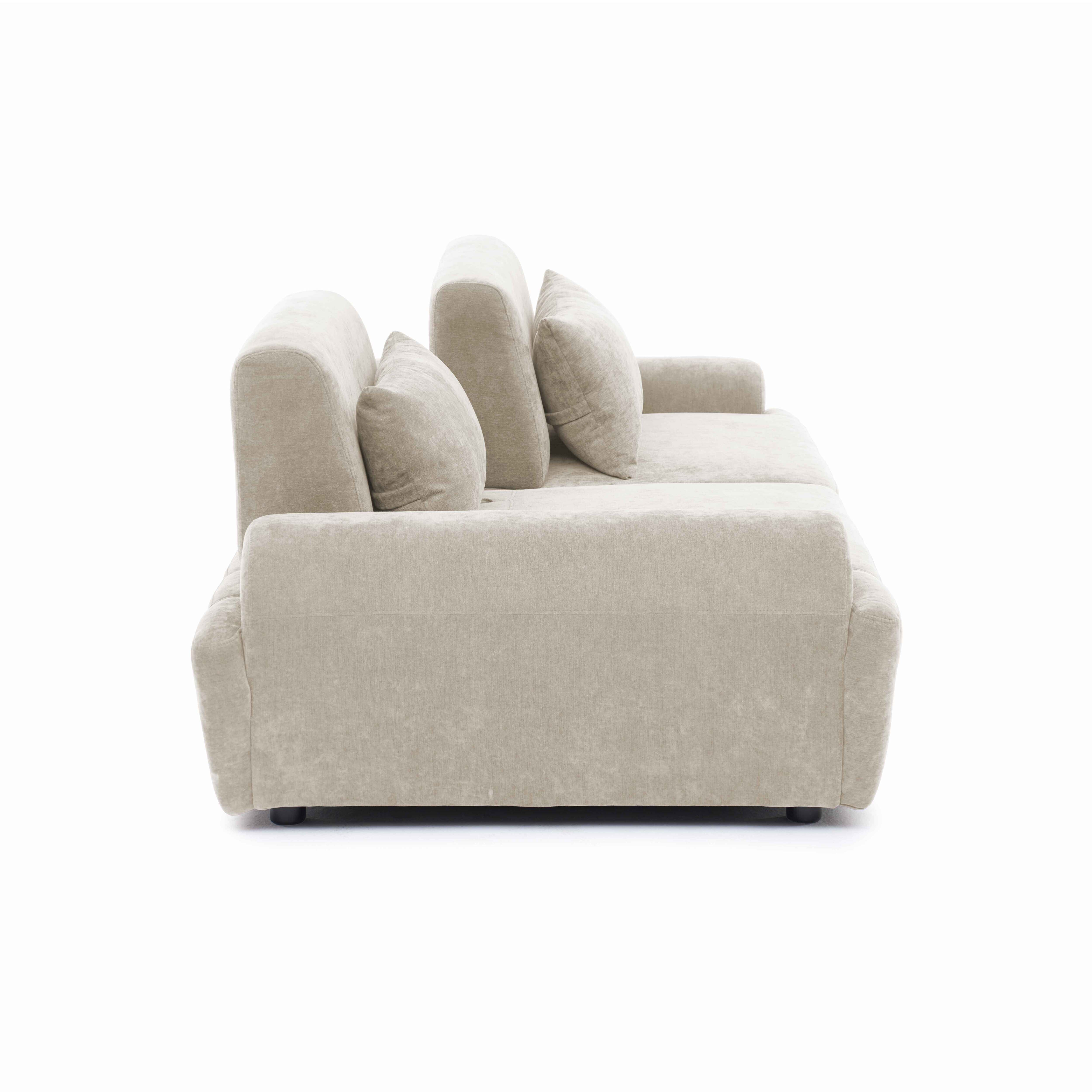 Ein beiger Stoffsofa mit Kissen, von der Seite gesehen auf weißem Hintergrund.