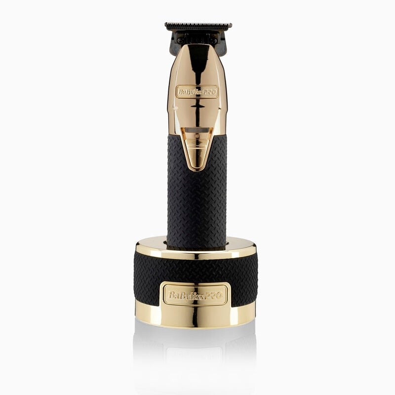 Un rifinitore per capelli senza fili dal design oro e nero poggia sulla base di ricarica.