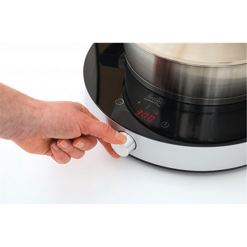 Una mano gira un mando en una placa de cocina con olla y pantalla digital.