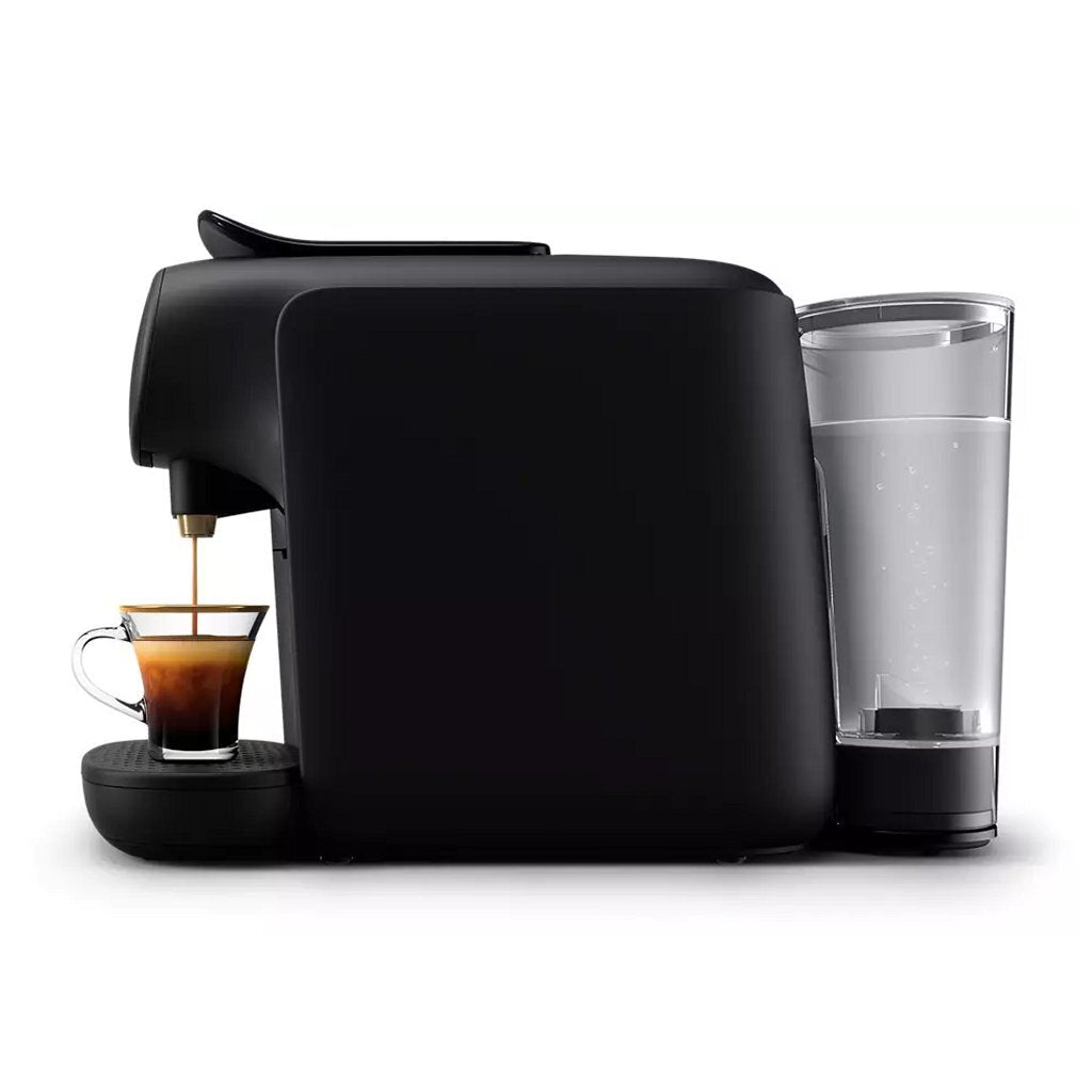 Eine schwarze Kaffeemaschine brüht Espresso in eine klare Glastasse mit goldenem Rand.