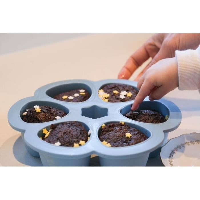 Ein Babyfinger berührt einen Schokoladenkuchen mit Sternstreuseln in einer blauen Form.