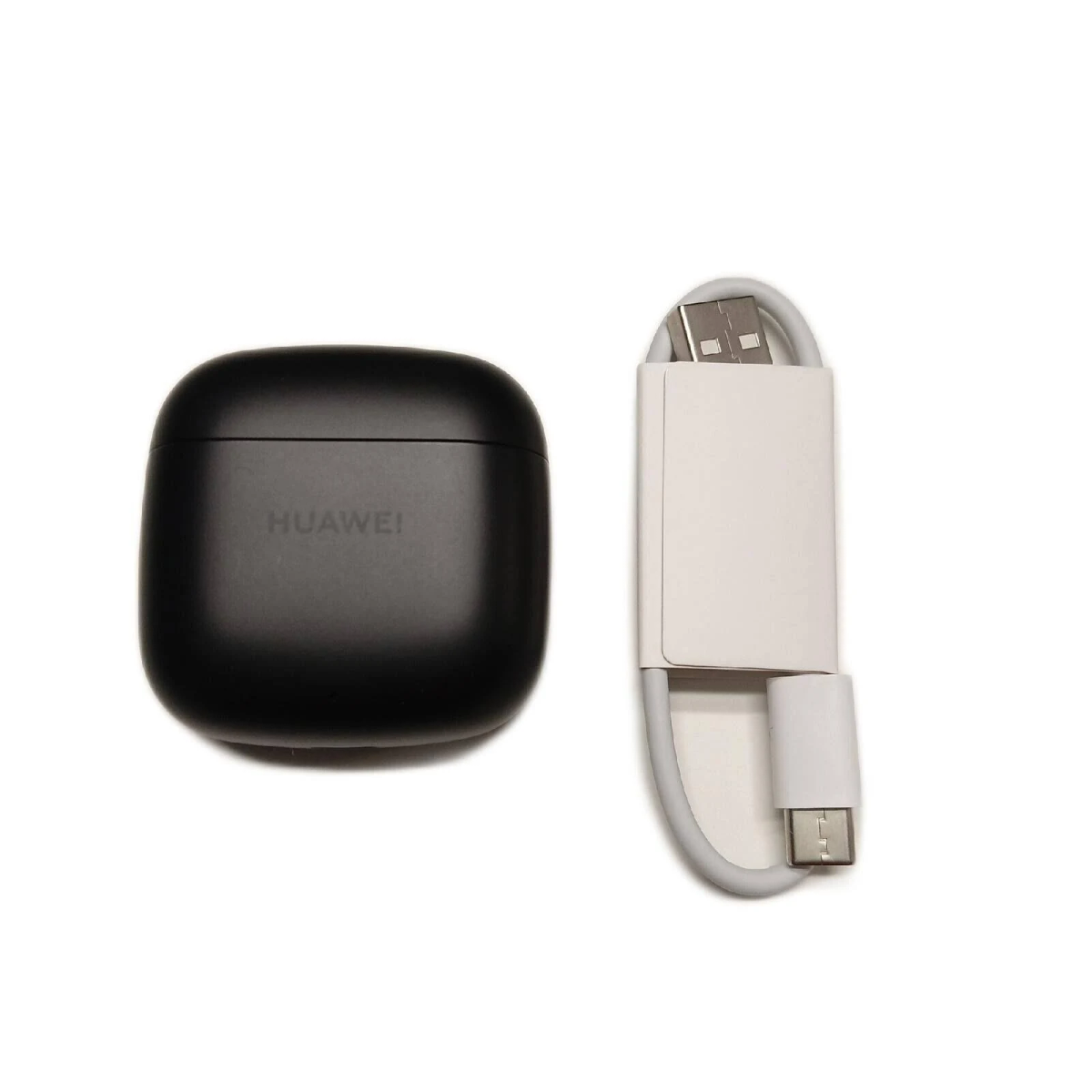 Custodia di ricarica Huawei nera accanto a un cavo bianco con connettore USB-C.