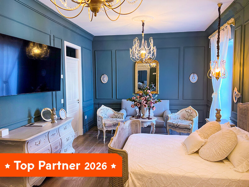 Un dormitorio de lujo con paredes azules, cama grande y zonas de estar.