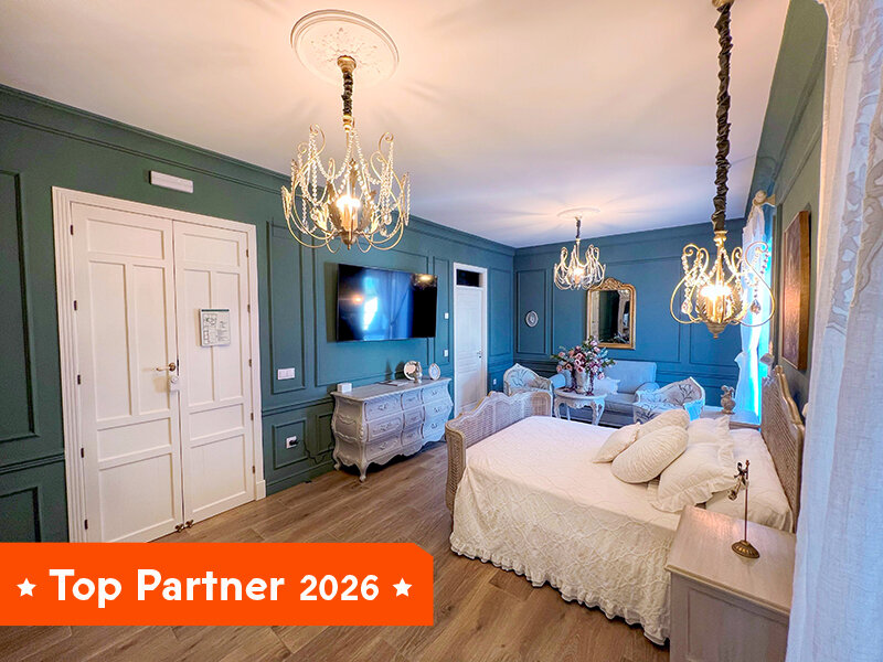 Un dormitorio con cama blanca, dos candelabros y paredes azules.