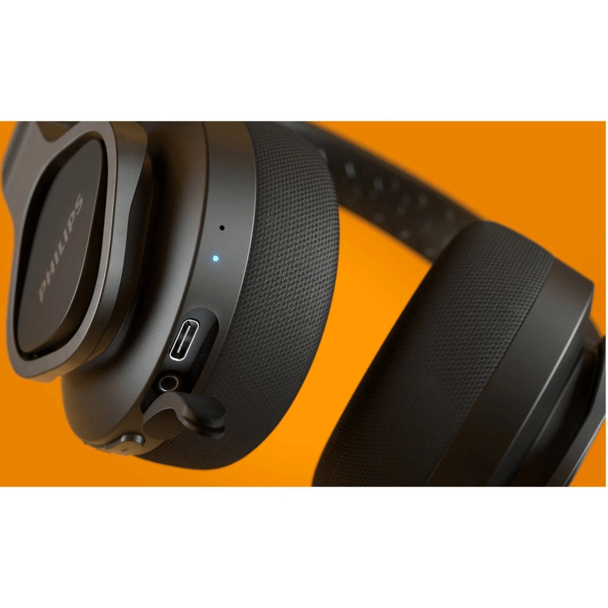 Auriculares negros con luz azul y puerto USB-C sobre fondo naranja.