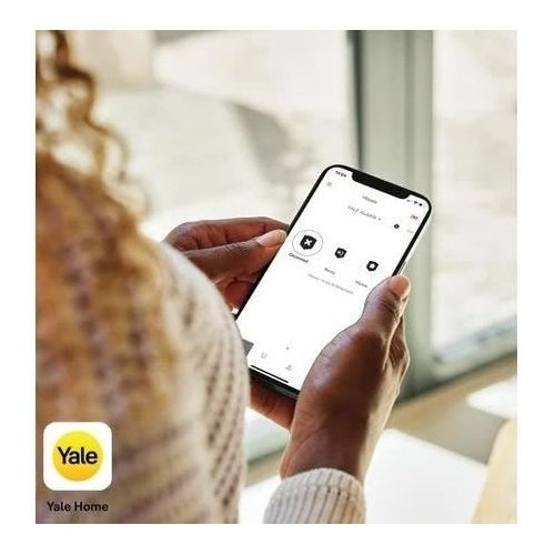 Osoba trzyma smartfon z otwartą aplikacją Yale Home.