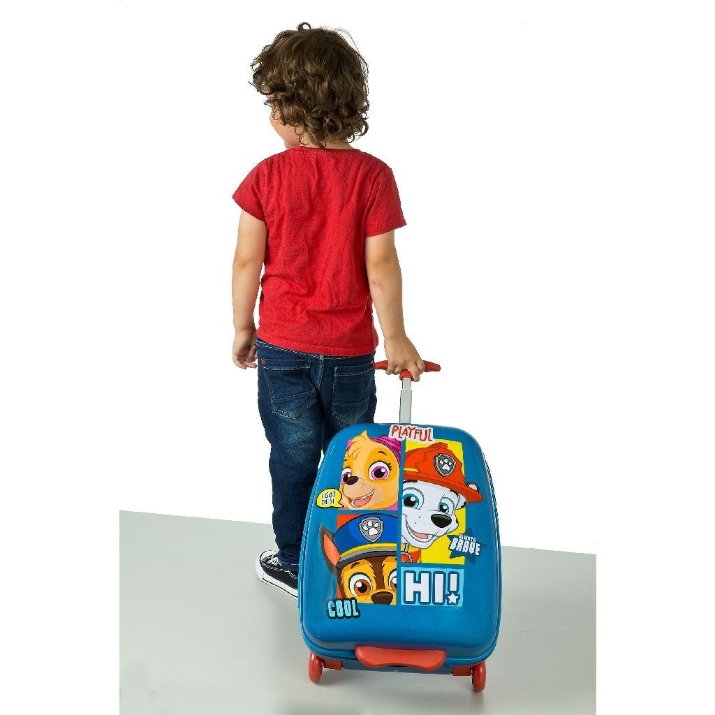 Ein Junge mit einem roten T-Shirt zieht einen blauen Paw Patrol Koffer.
