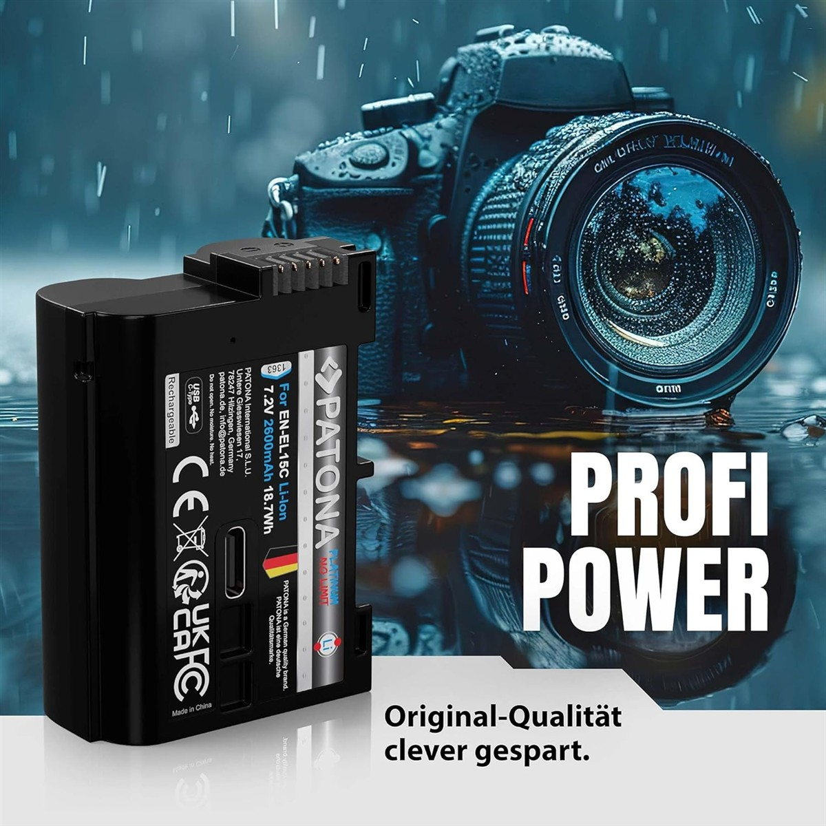 Eine schwarze Kamera-Batterie liegt auf nassem Boden vor einer Kamera.