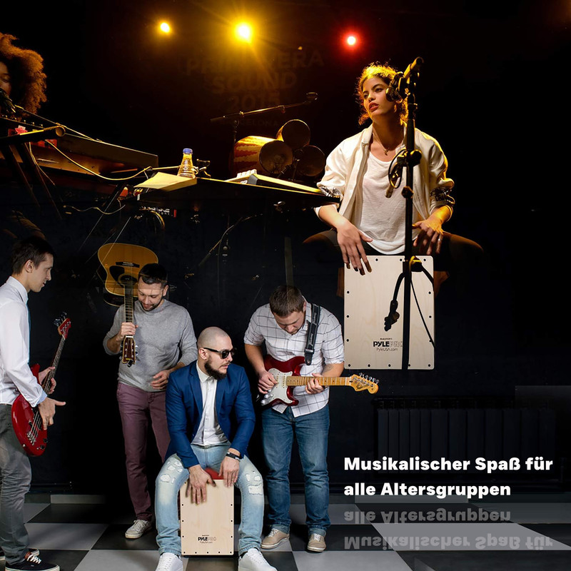 Eine Band probt mit Gitarren, Schlagzeug und Cajon. Eine Frau singt.