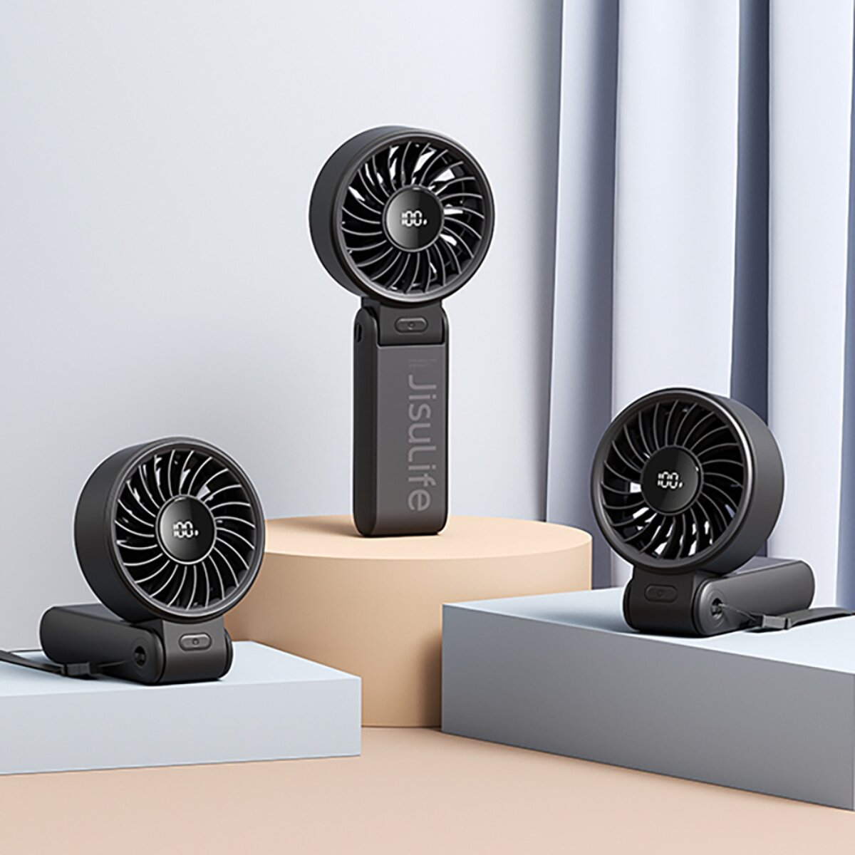 Tre ventilatori portatili neri con display digitali su piedistalli.