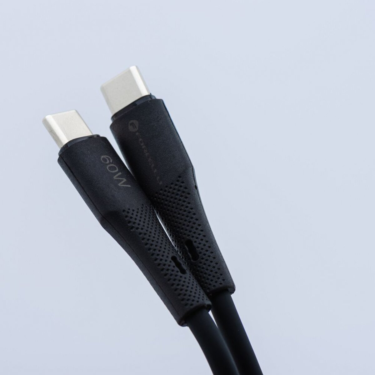Zwei schwarze USB-C-Kabel mit silbernen Steckern auf hellgrauem Hintergrund.